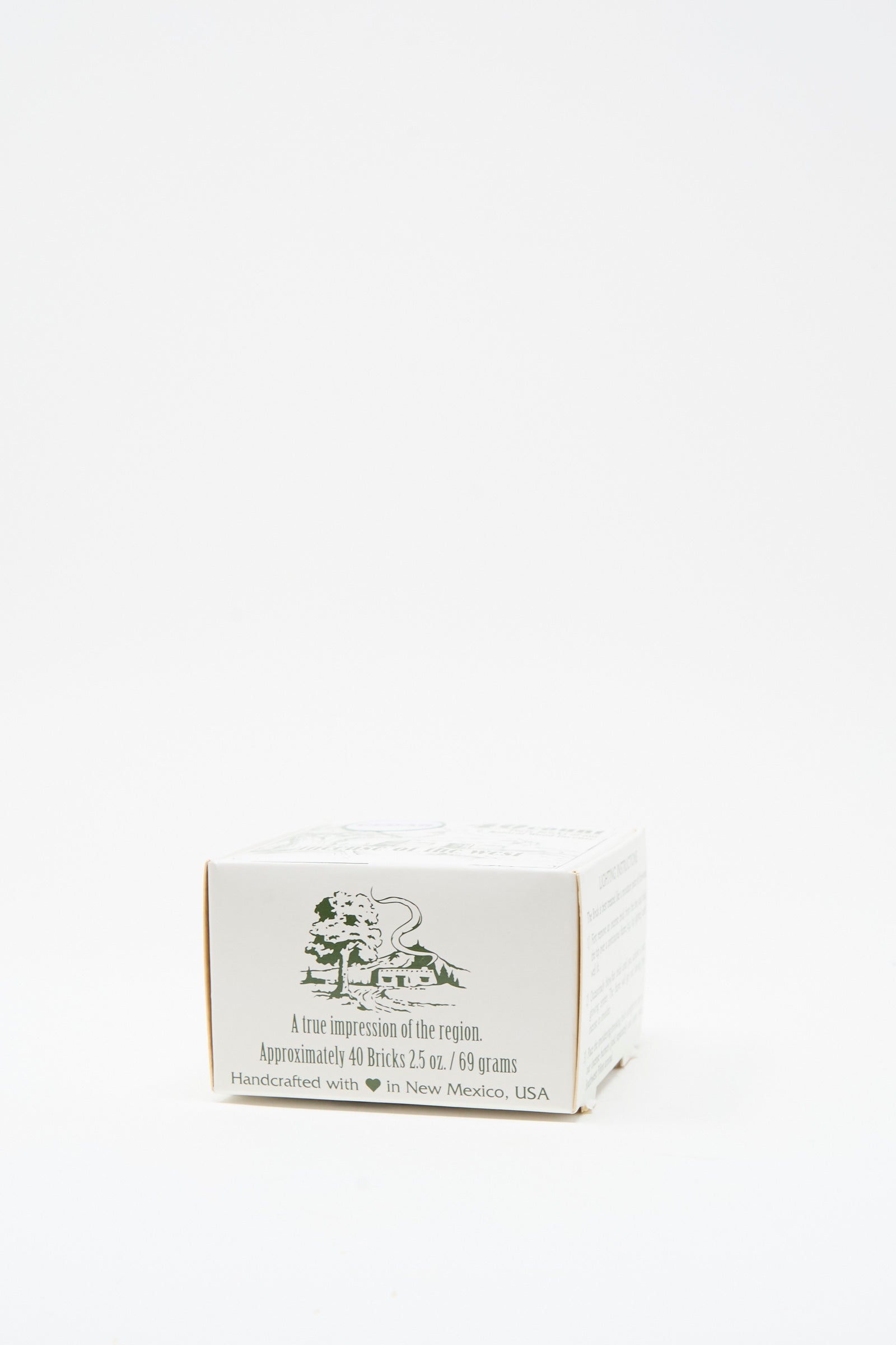The Cedar Incense Box by Incense of the West is a small white box with green text and a lion illustration, containing about 40 handcrafted bricks made from New Mexican clay in New Mexico, USA.