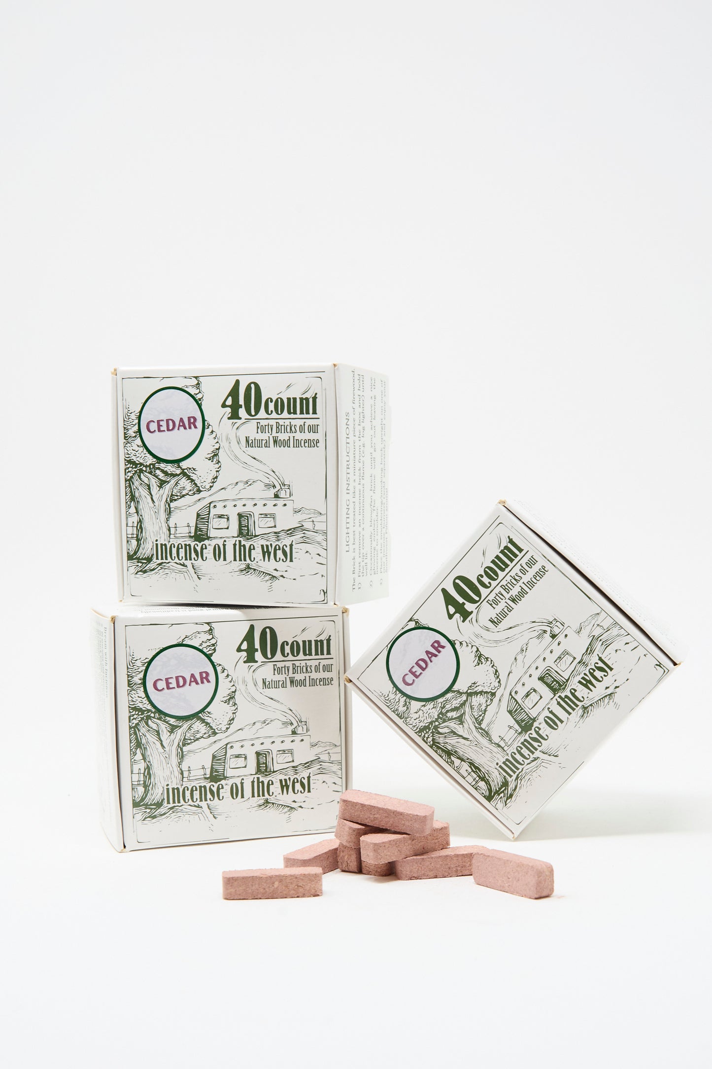 Three Cedar Incense Box products from Incense of the West, along with brown incense bricks, are displayed against a white background—perfect for filling your space with natural cedar aroma using your incense burner.