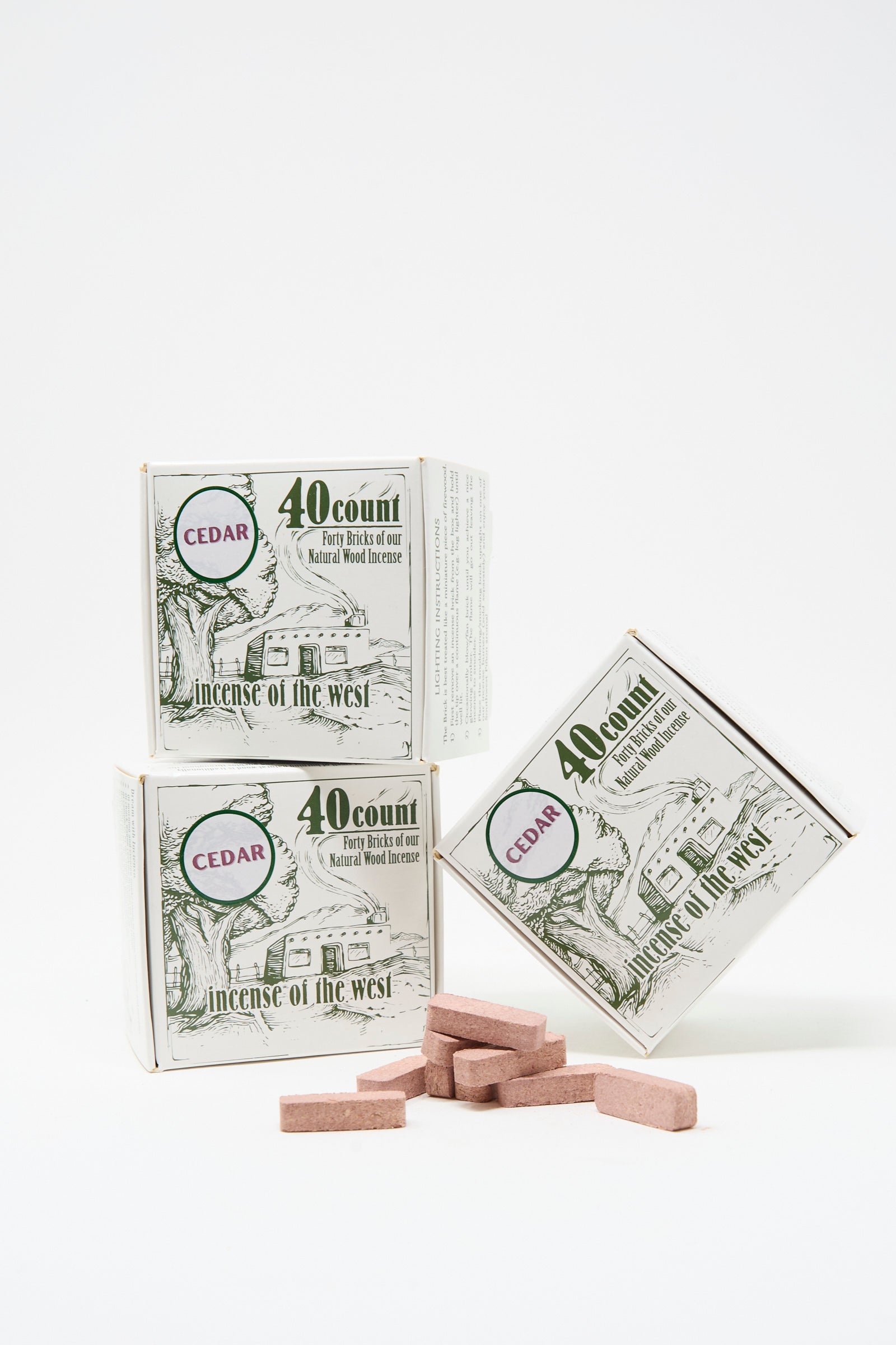 Three Cedar Incense Box products from Incense of the West, along with brown incense bricks, are displayed against a white background—perfect for filling your space with natural cedar aroma using your incense burner.