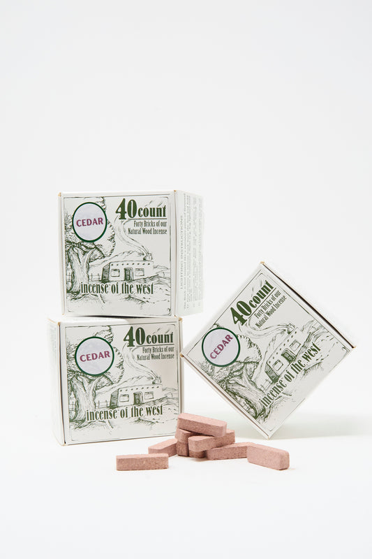Three Cedar Incense Box products from Incense of the West, along with brown incense bricks, are displayed against a white background—perfect for filling your space with natural cedar aroma using your incense burner.