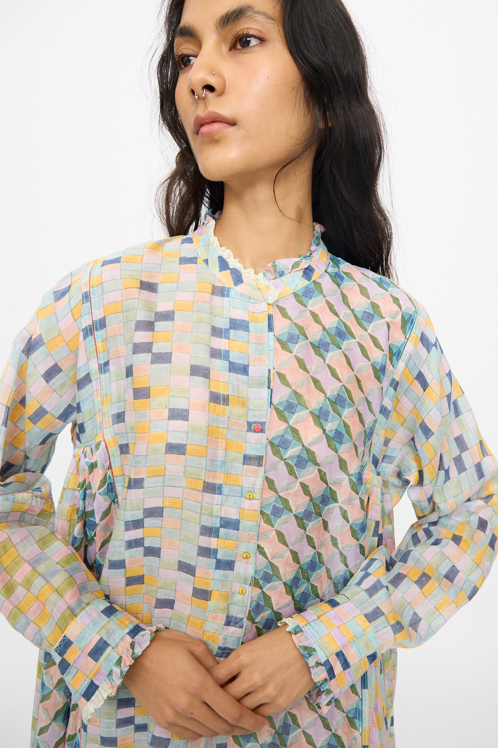 A person wears the Injiri Blockprint Chanderi Trumpet Dress in Blue Yellow Multi, featuring geometric patchwork, against a plain light background.