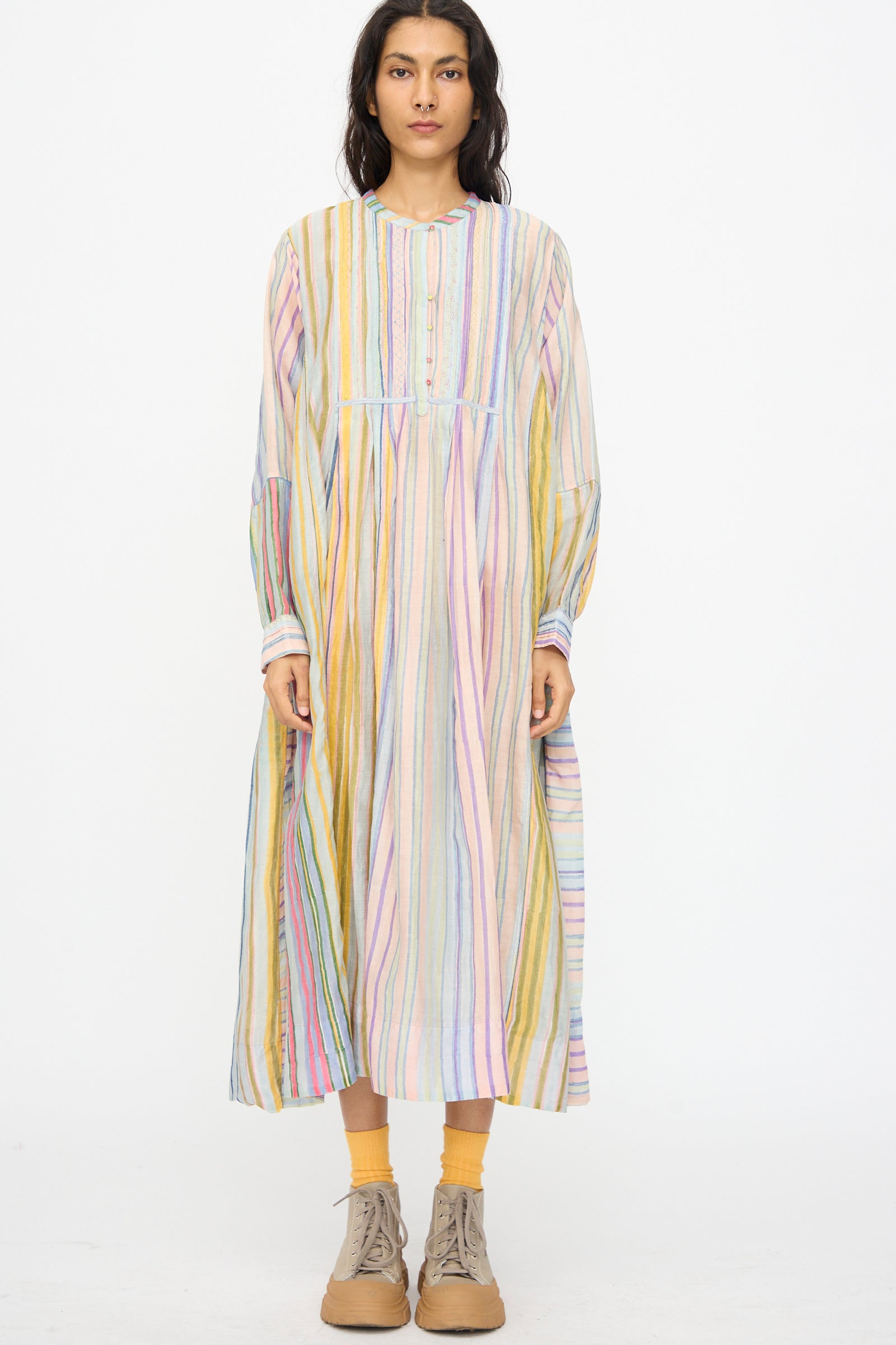 A woman in the Injiri Blockprint Chanderi Trumpet Dress in Multi Stripe, paired with mustard socks and tan lace-up shoes, stands against a plain white background.