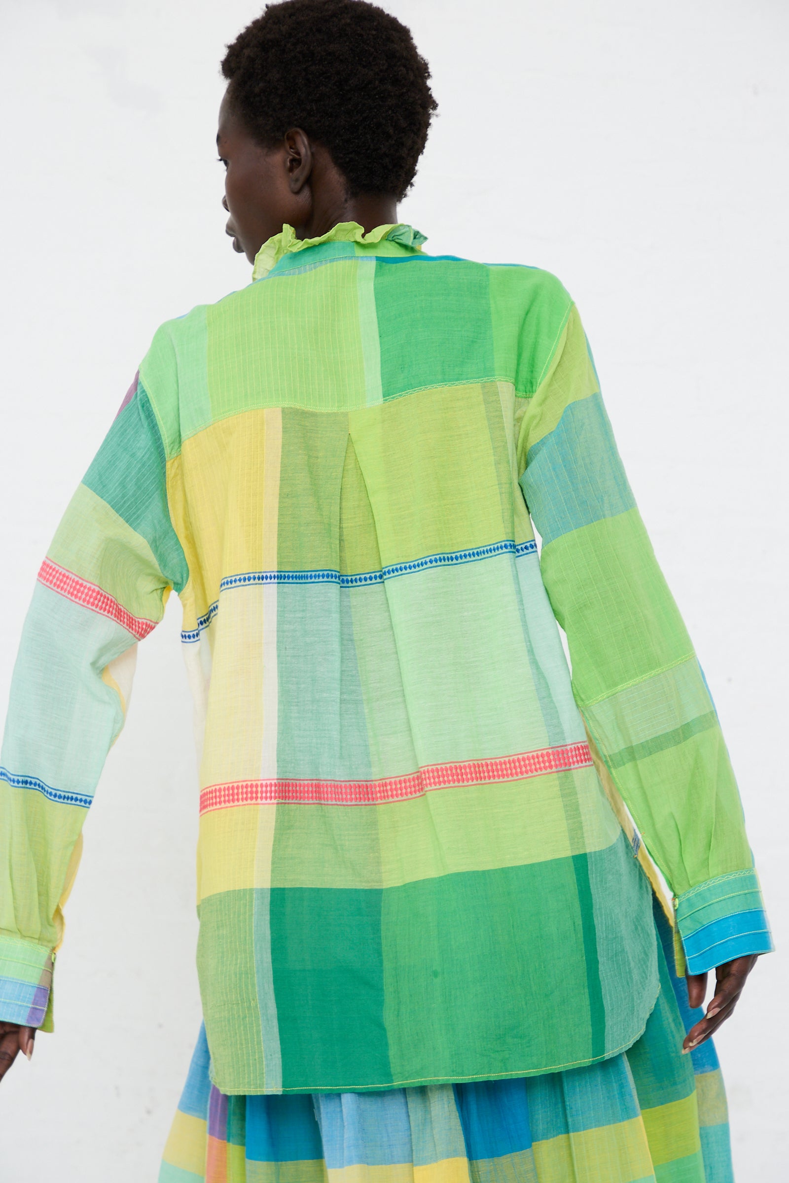 Rear view of a person wearing an Injiri Cotton Shirt in Green, Yellow and Pink Check against a plain white background.
