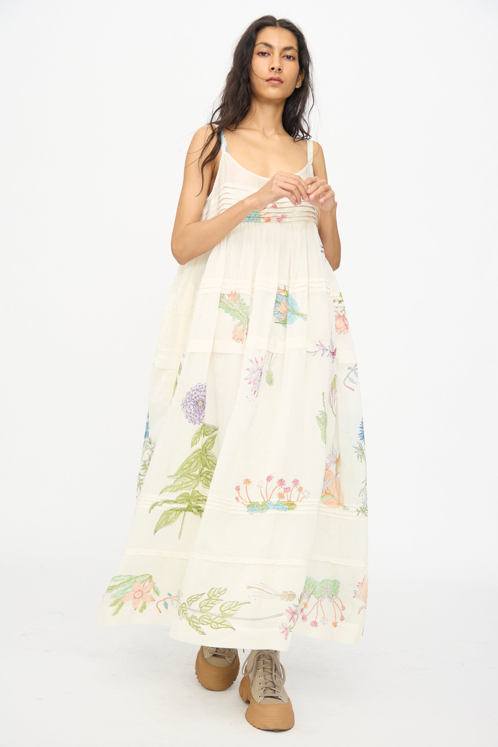 A woman models Injiri’s Cotton Silk Blockprint Hazel Slip in White Floral, styled with tan lace-up shoes, against a plain white background.