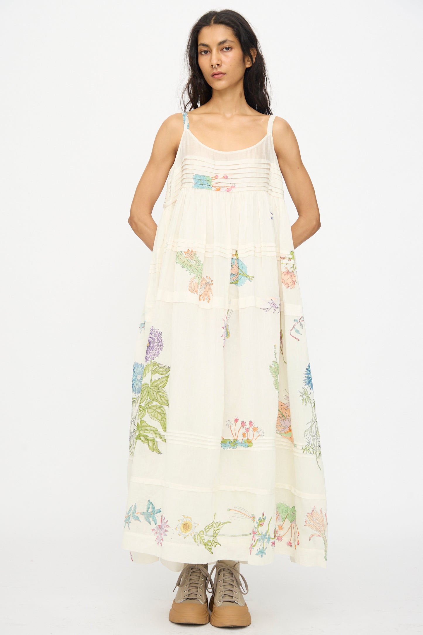 A woman stands facing forward in the Injiri Cotton Silk Blockprint Hazel Slip in White Floral, paired with beige lace-up shoes, against a plain white background.