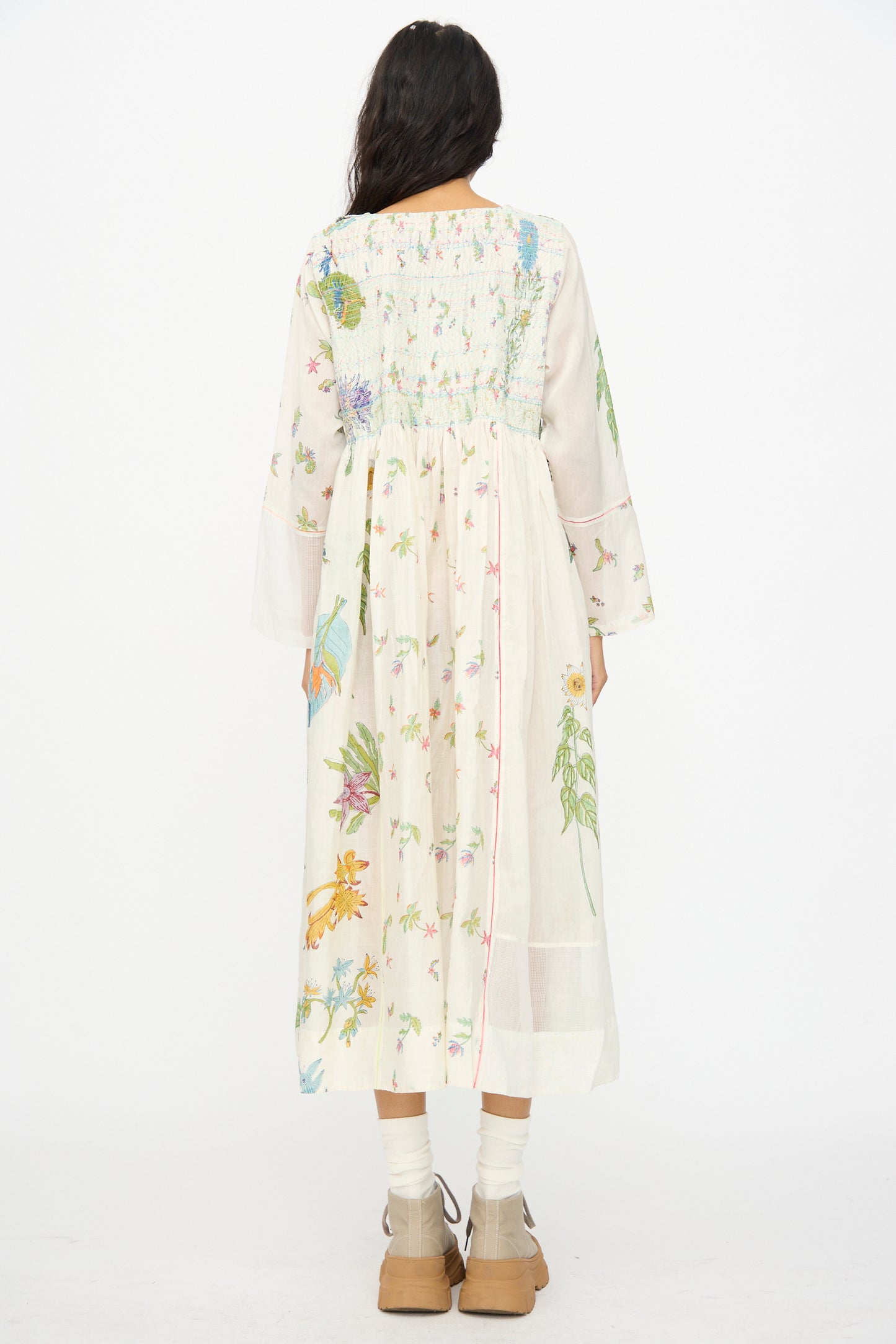 A person wearing the Injiri Cotton Silk Blockprint Nazma Dress in White, paired with tan shoes and white socks, photographed from the back against a plain white background.