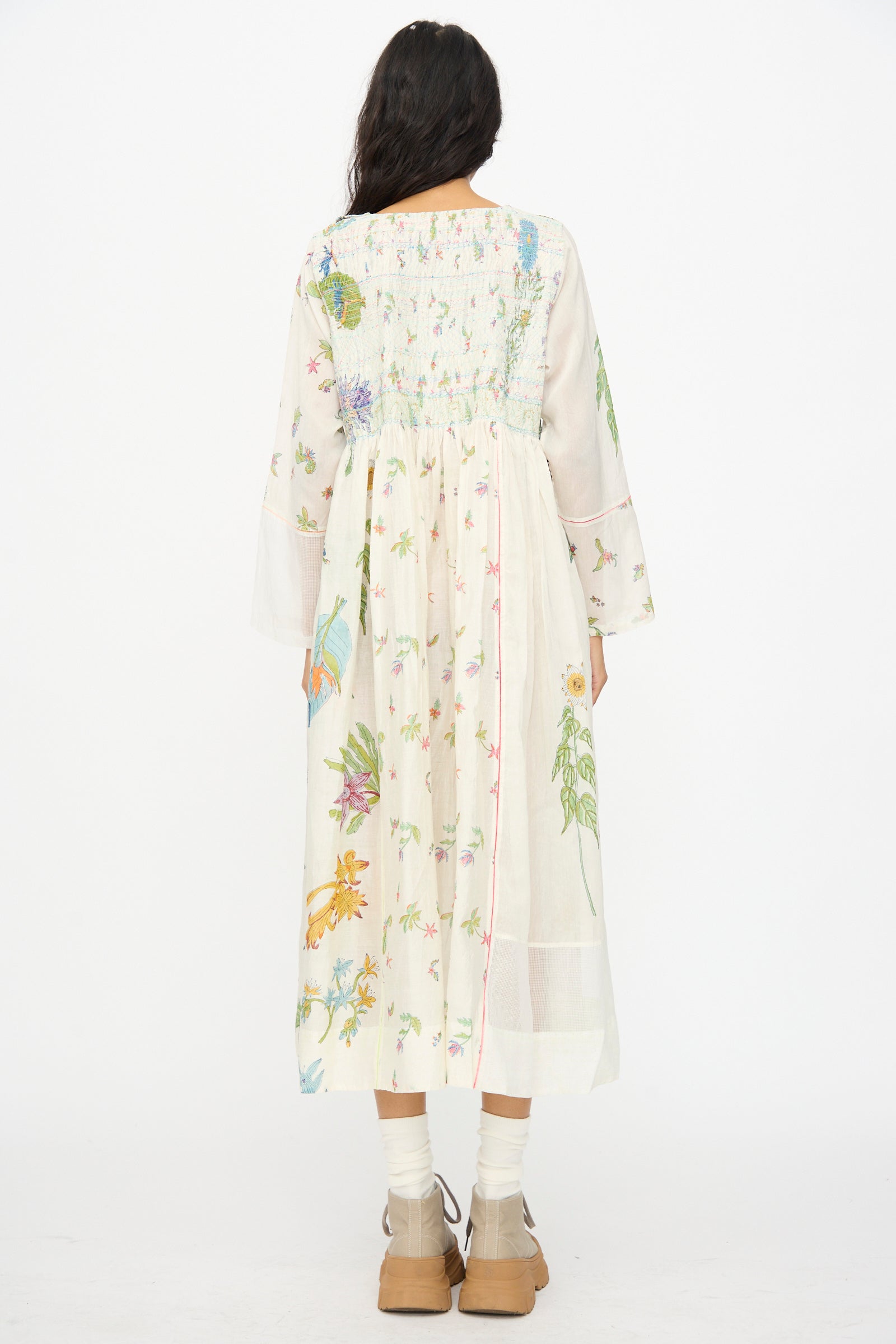 A person wearing the Injiri Cotton Silk Blockprint Nazma Dress in White, paired with tan shoes and white socks, photographed from the back against a plain white background.