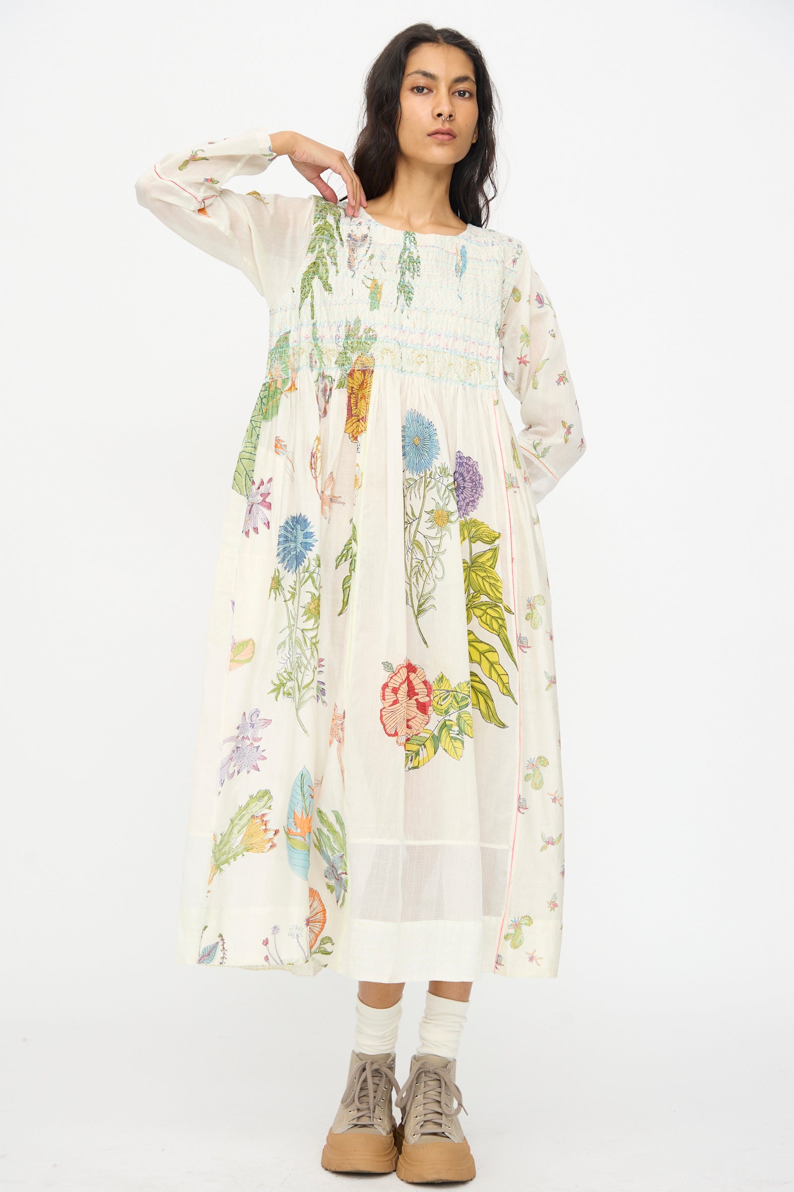 A woman wears the Injiri Cotton Silk Blockprint Nazma Dress in White, showcasing delicate block-printed cotton silk, paired with socks and brown shoes against a plain white background.