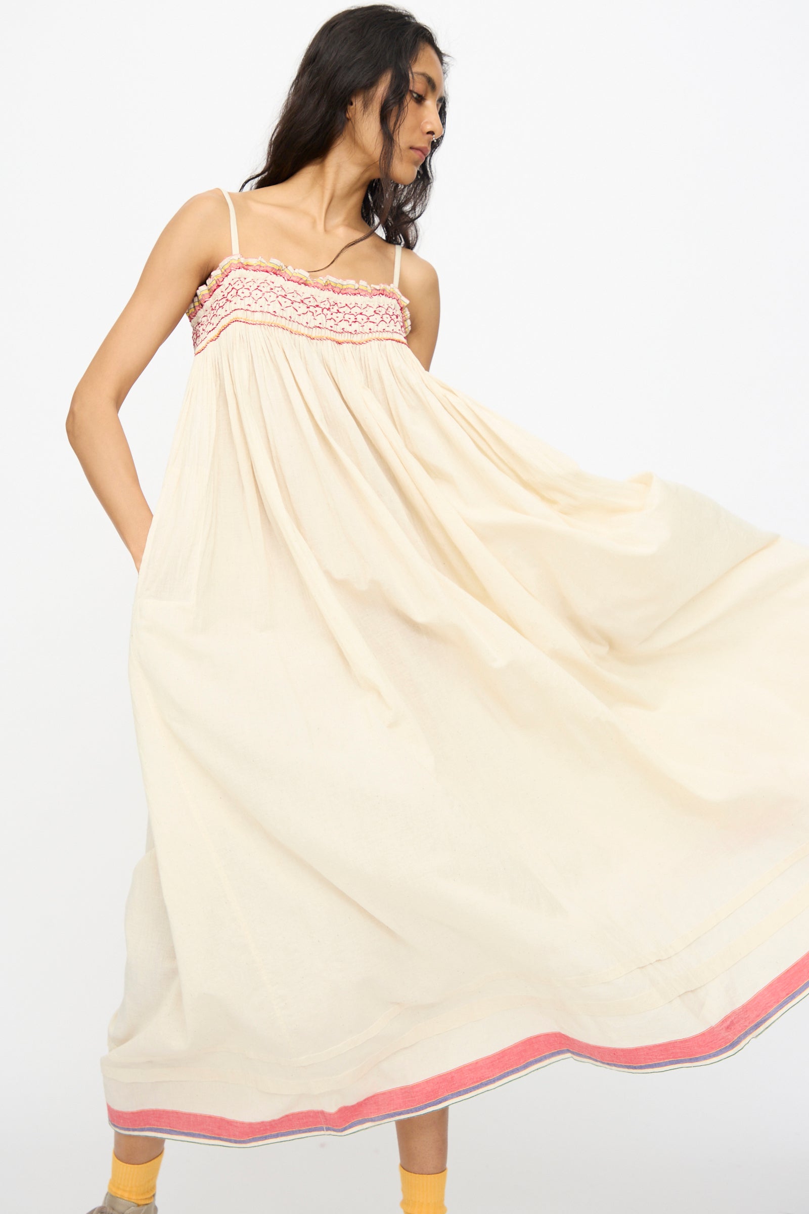 A woman models the Injiri Woven Cotton Slip Dress in white with red stitch, posing against a plain white background.