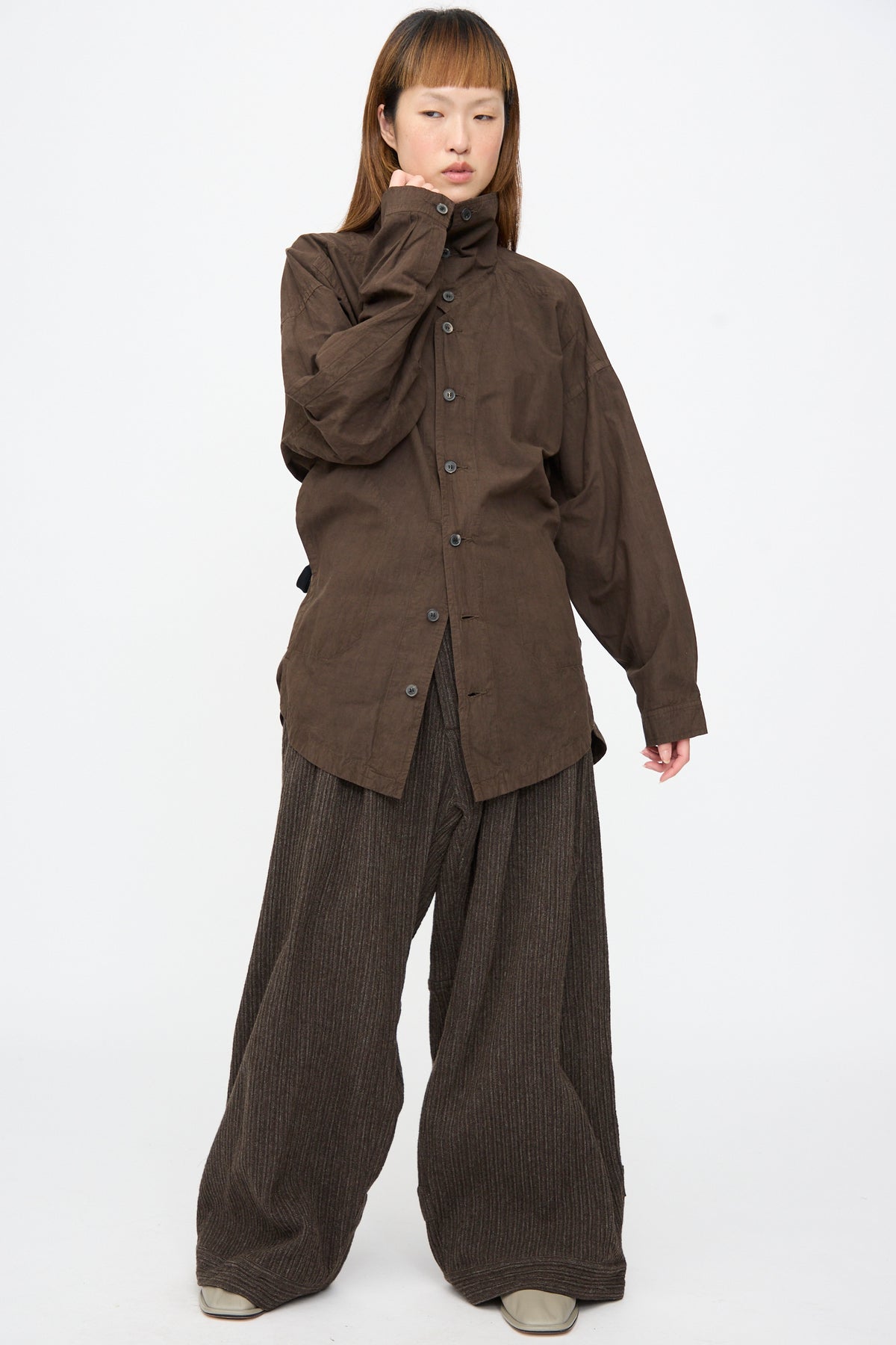 A person wearing a Jan-Jan Van Essche Cotton Wool Shirt #110 in Doro Zome over wide-leg trousers.