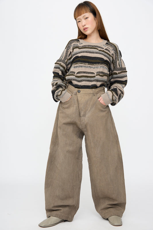 A person wearing a textured, striped long-sleeve sweater and Hemp Bamboo Twill Trousers #90 in Kakishibu and Iron, featuring a relaxed fit and deep side pockets.