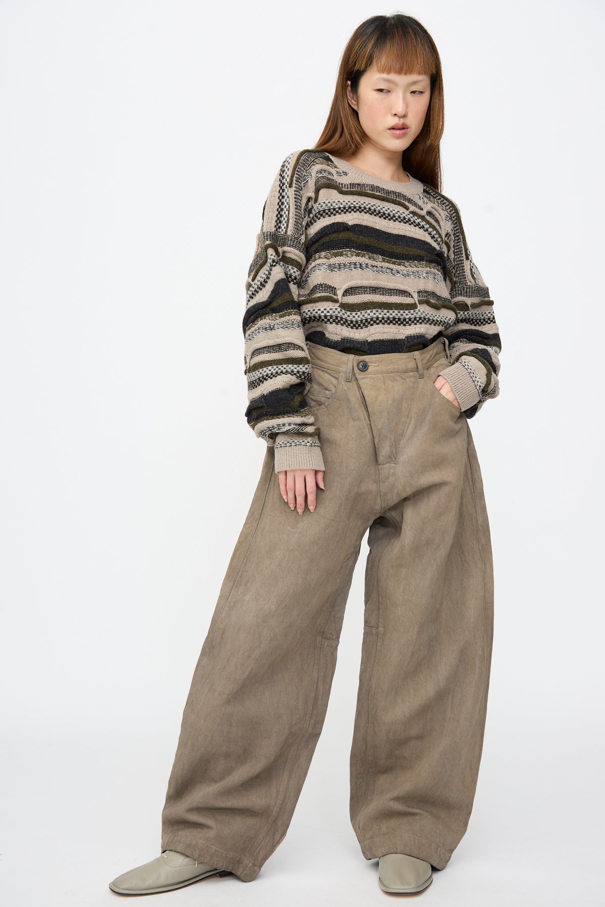 A person wears a textured, striped knit sweater with relaxed-fit Hemp Bamboo Twill Trousers #90 in Kakishibu and Iron.