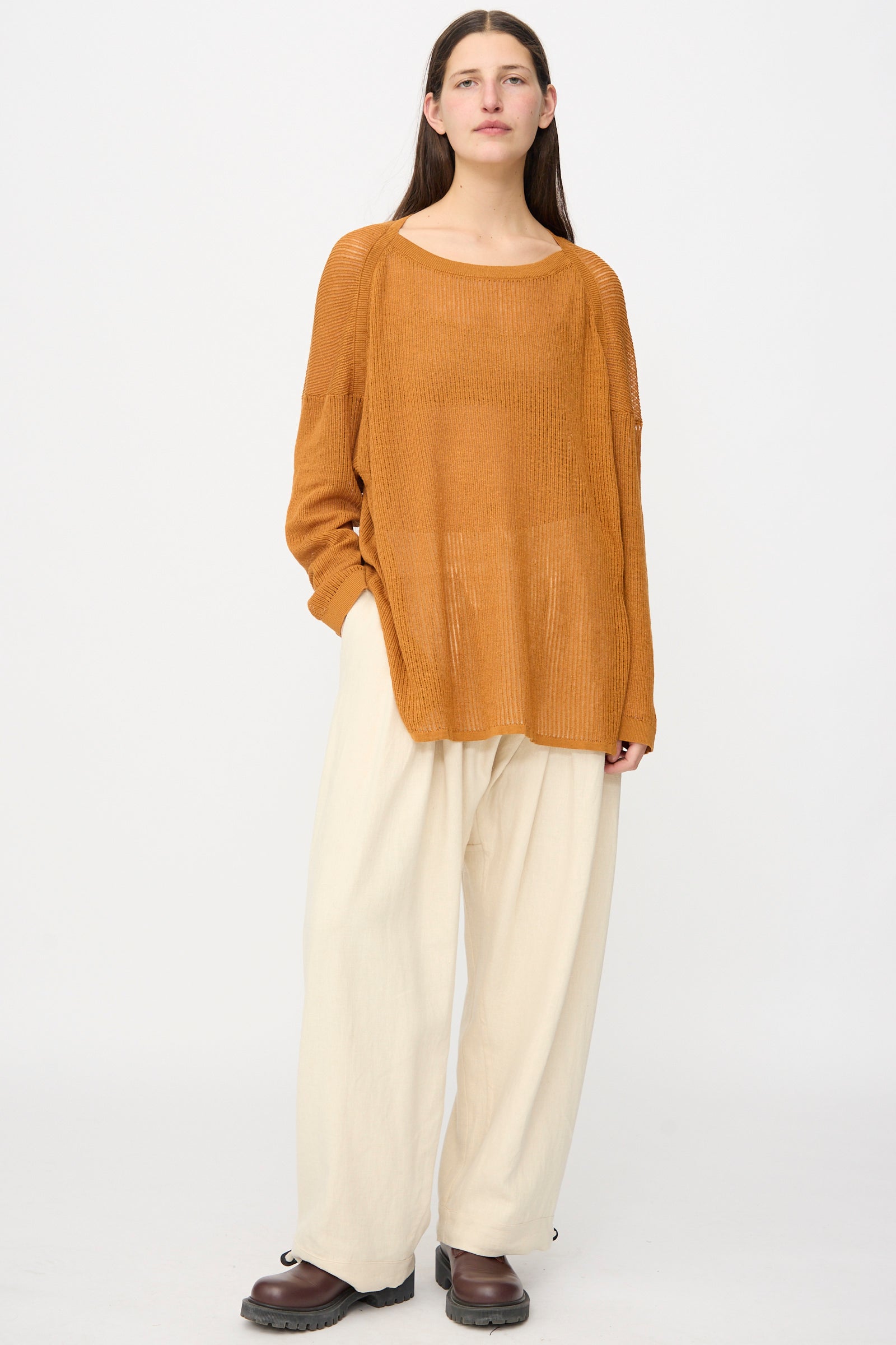 A person stands against a plain background wearing a loose brown sweater, dark brown shoes, and Jan-Jan Van Essche Hemp Soft Canvas Trousers #91 in Kinari featuring an elasticated waistband.