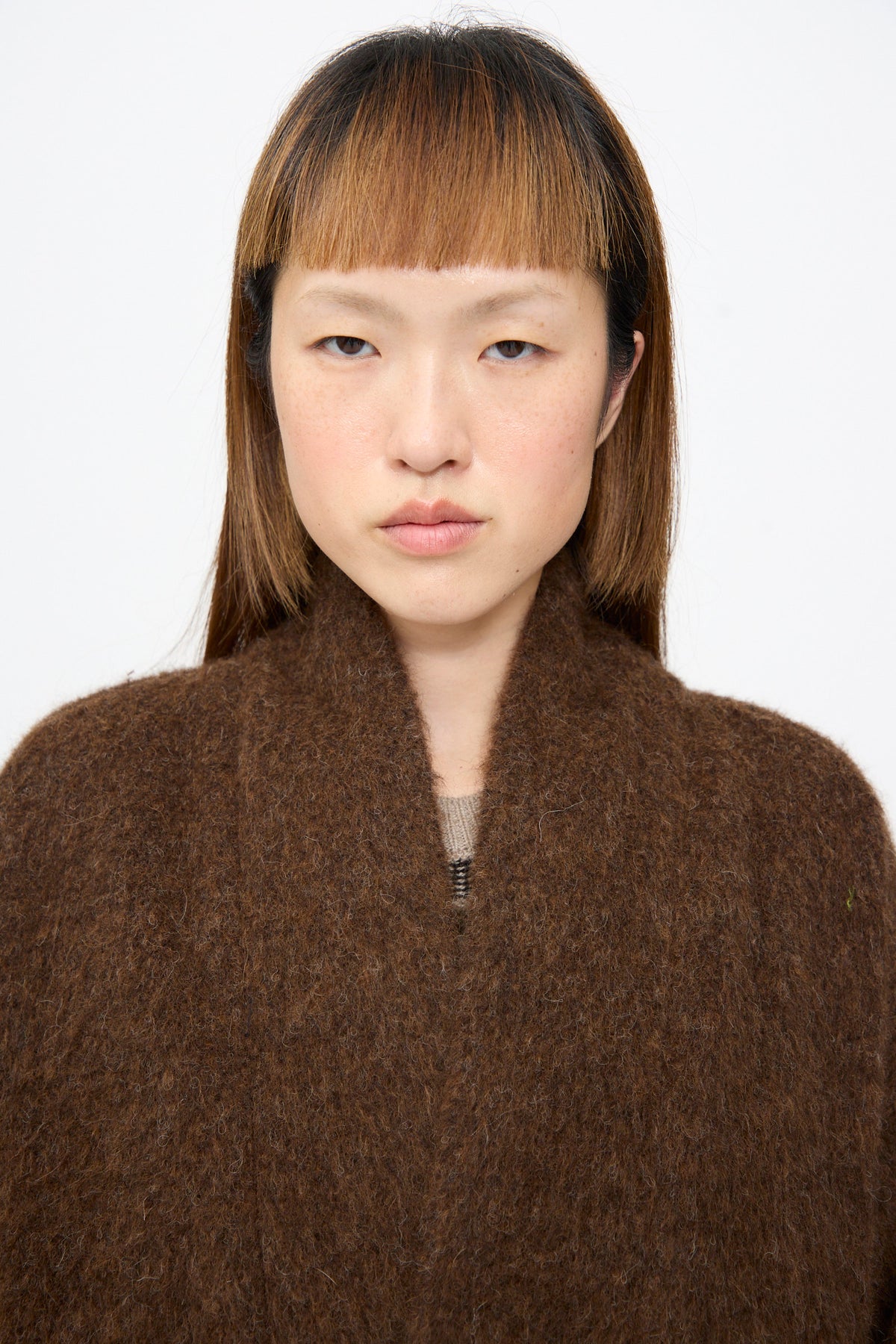 A person wearing a Jan-Jan Van Essche Highpile Herringbone Coat #35 in Brown Alpaca, an oversized coat with a high-pile texture and a wide collar.