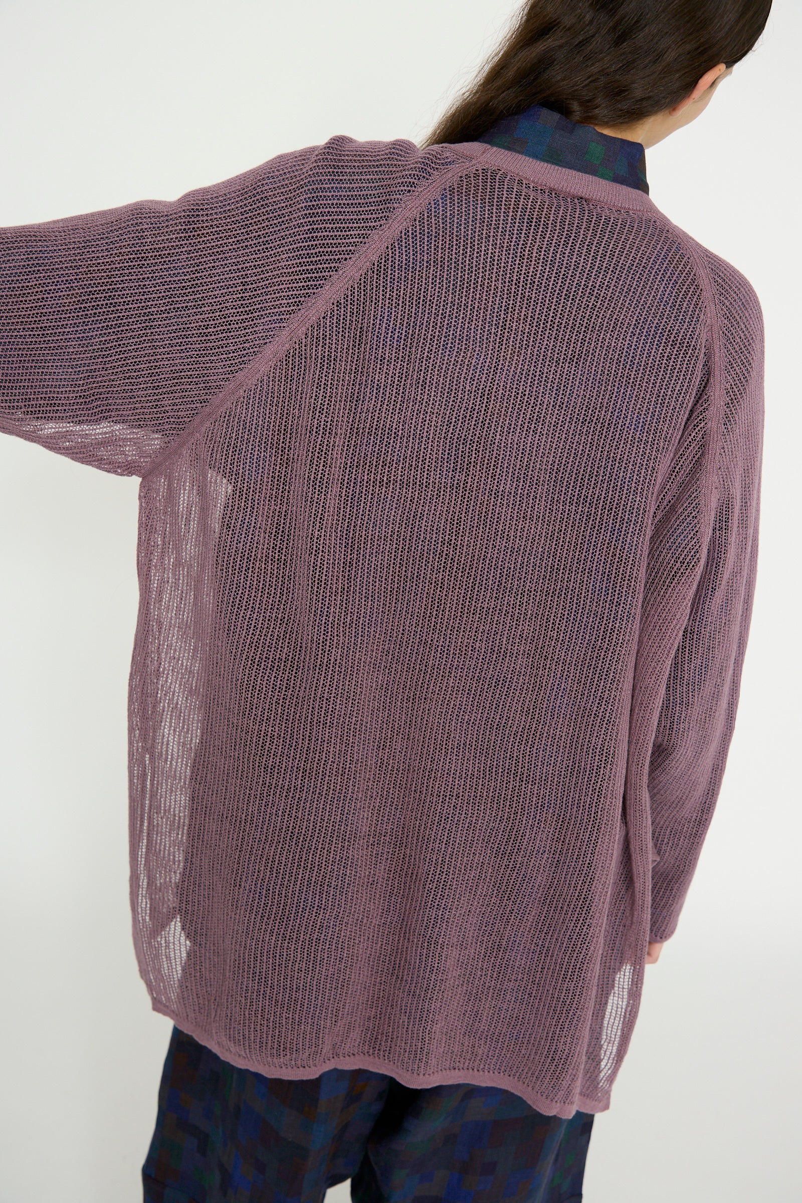 A person wearing the Jan-Jan Van Essche Linen Cotton Yarn Knit #69 in Lavender, with rib knit trims and a loose fit, seen from the back with one arm outstretched.