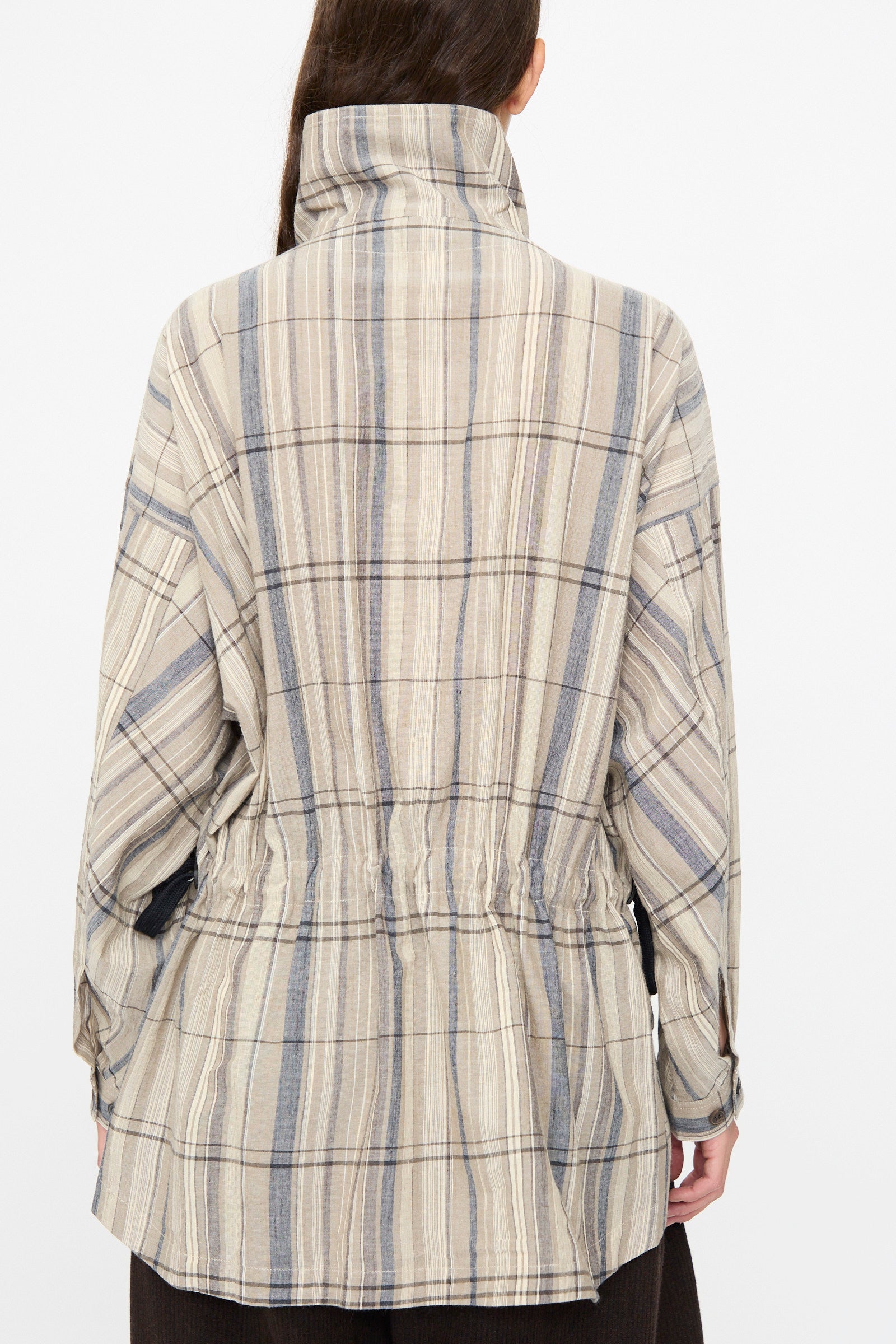 Person shown from the back wearing the Jan-Jan Van Essche Madras Plaid Shirt #110 in Plaster, a beige, blue, and gray cotton-blend button-up with a high collar and cinched waist detail for added shape.