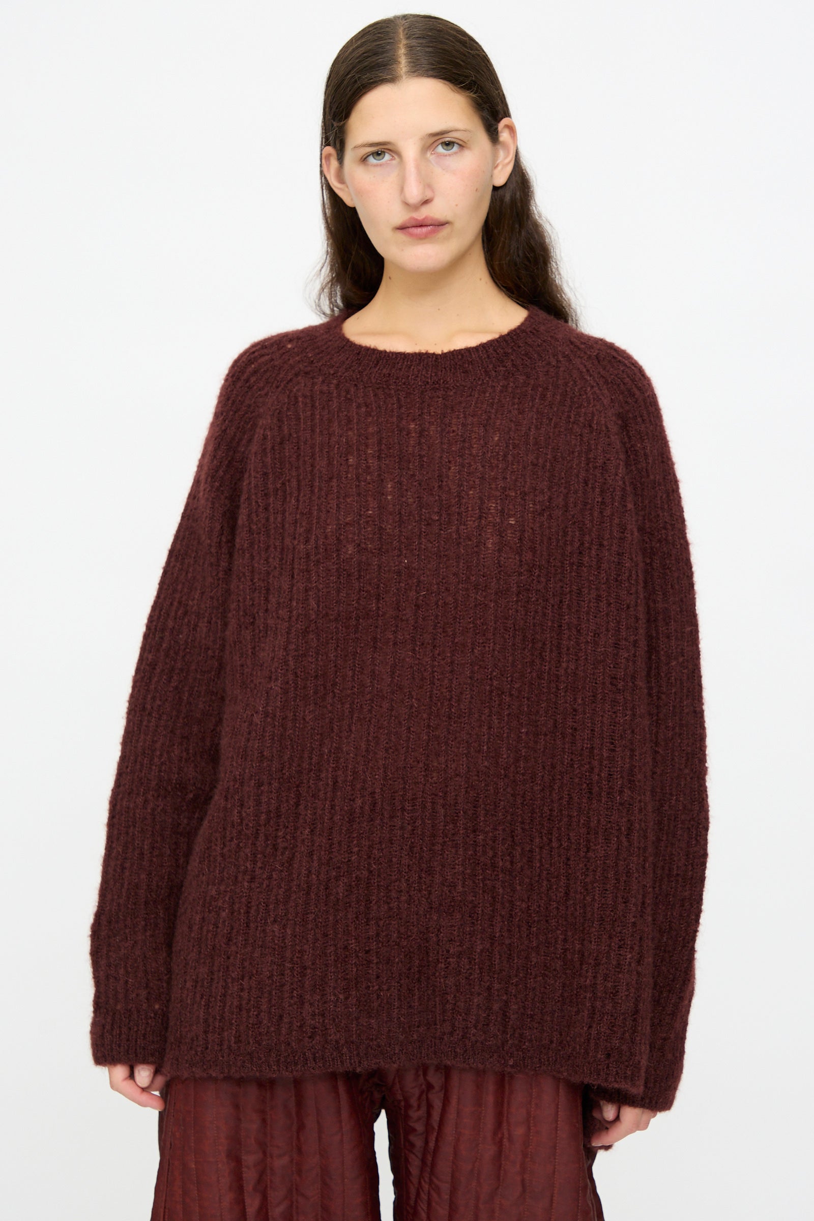 A person with long brown hair wears the Jan-Jan Van Essche Mohair Knit #71 Sweater in Oxblood and matching pants, standing against a plain white background.