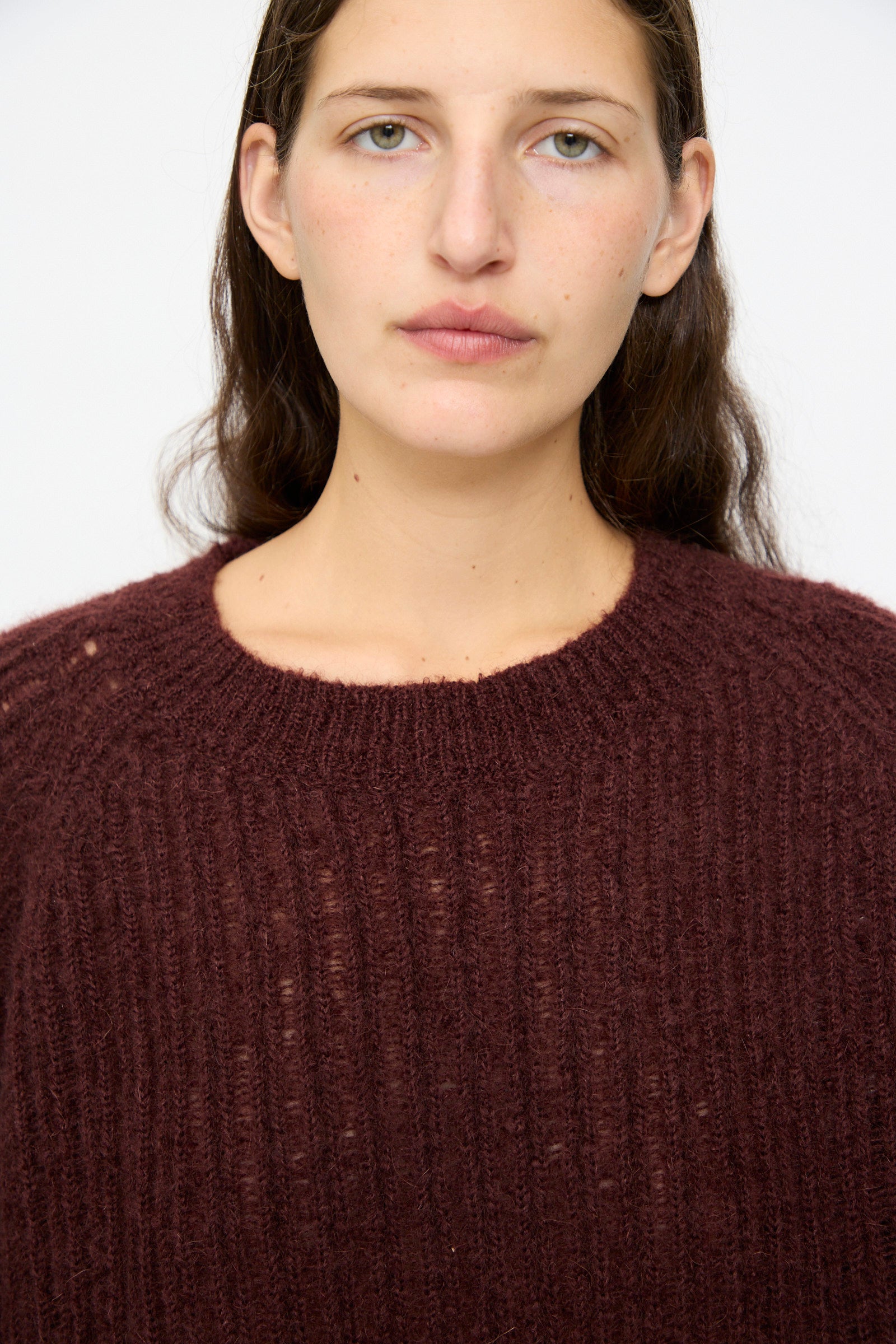 A person with long brown hair wears the Jan-Jan Van Essche Mohair Knit #71 Sweater in Oxblood, looking directly at the camera against a plain background.