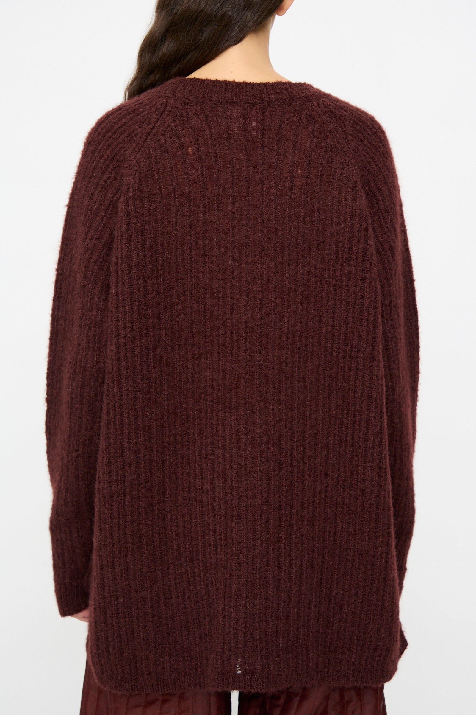 Model wears the Jan-Jan Van Essche Mohair Knit #71 Sweater in Oxblood, featuring an oversized fit, long sleeves, and a ribbed maroon texture, shown from the back against a plain background.