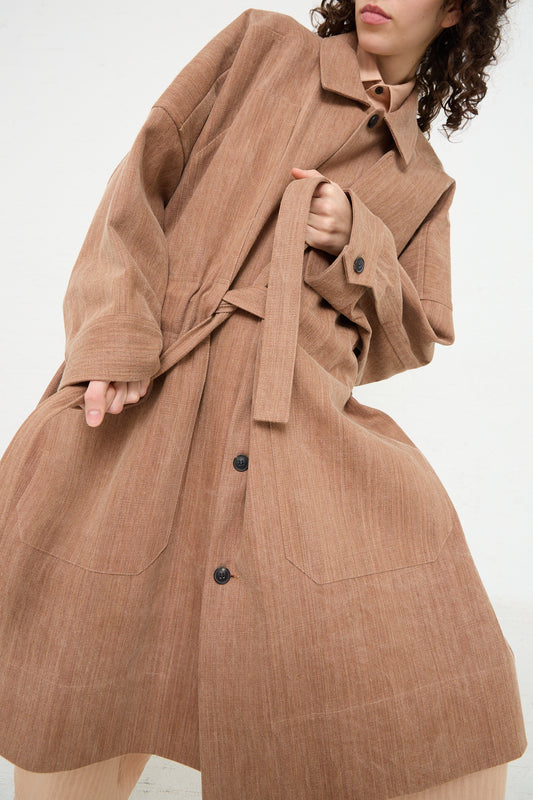 A woman in a brown trench coat made of heavy, natural dyed cotton with a self tie belt.
Product Name: Woven Cotton Long Coat in Kakishibu
Brand Name: Jan-Jan Van Essche