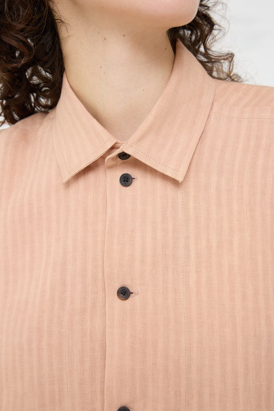The model is wearing a Woven Linen Shirt in Ume (Pink) by Jan-Jan Van Essche.