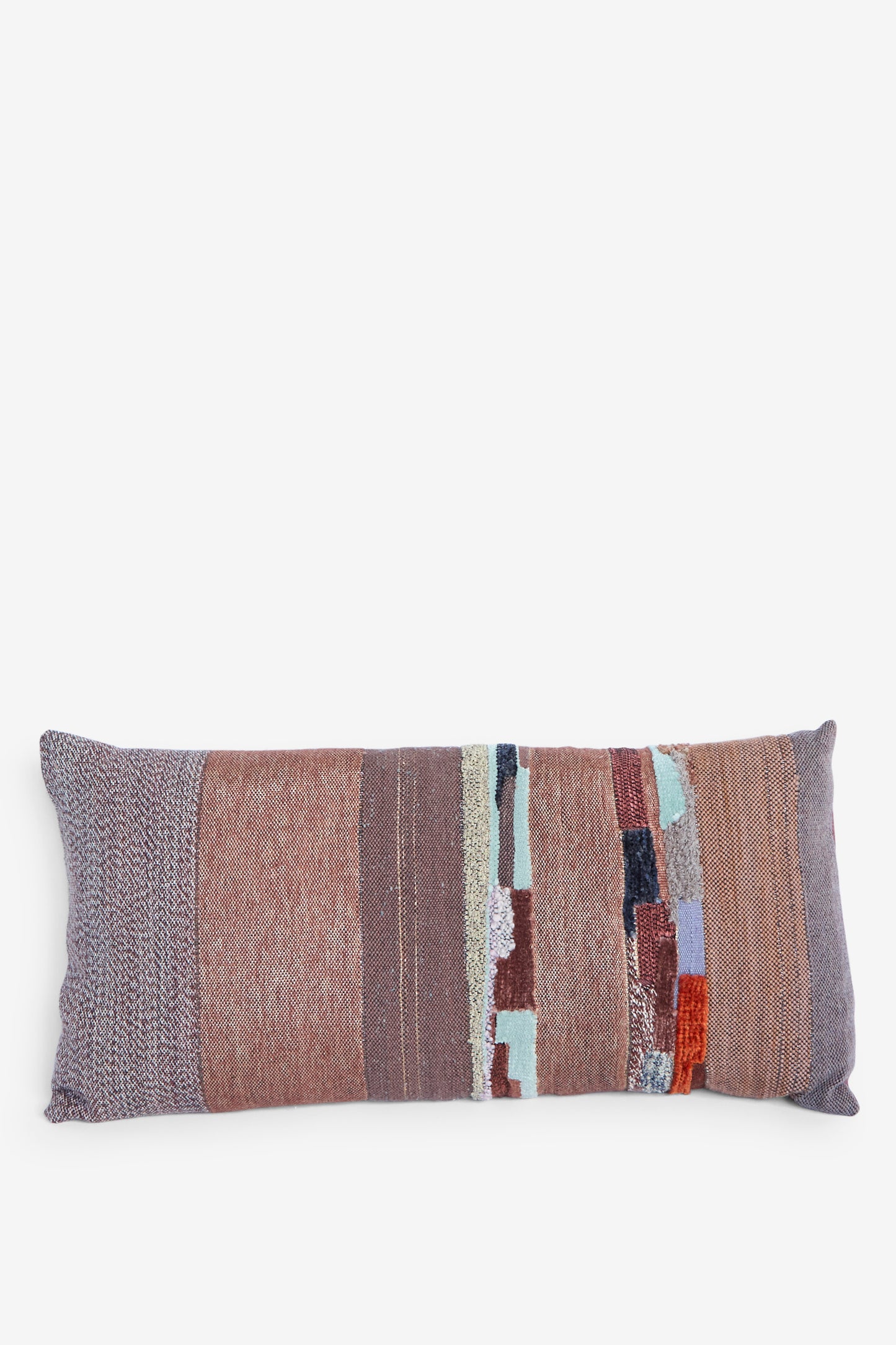 The Handwoven Tapestry Color Block Pillow in Copper and Rust by Jess Feury features a rectangular patchwork design in earthy tones, including brown, gray, and muted pastel, sits horizontally against a white background. 