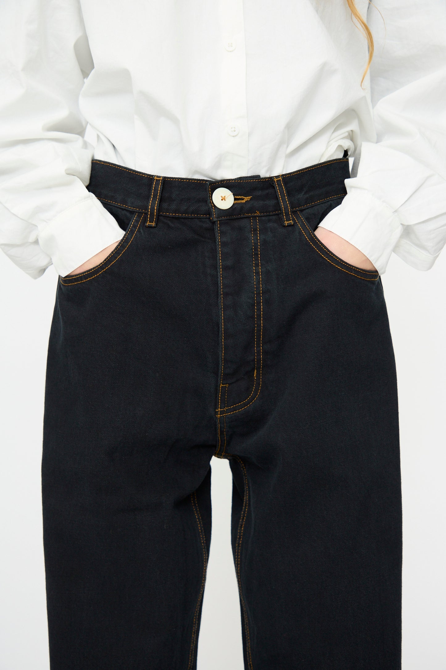 Person wearing a white button-up shirt and Jesse Kamm's California Wide in Black Overdye, shown from shoulders to thighs with hands in pockets.