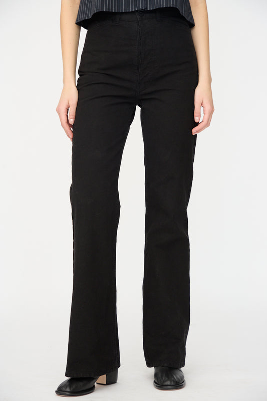 A person wears Jesse Kamm’s Canvas Les Deux Pants in Black, crafted from organic cotton canvas in California, paired with black shoes and photographed against a white background. The upper body is partially out of frame.