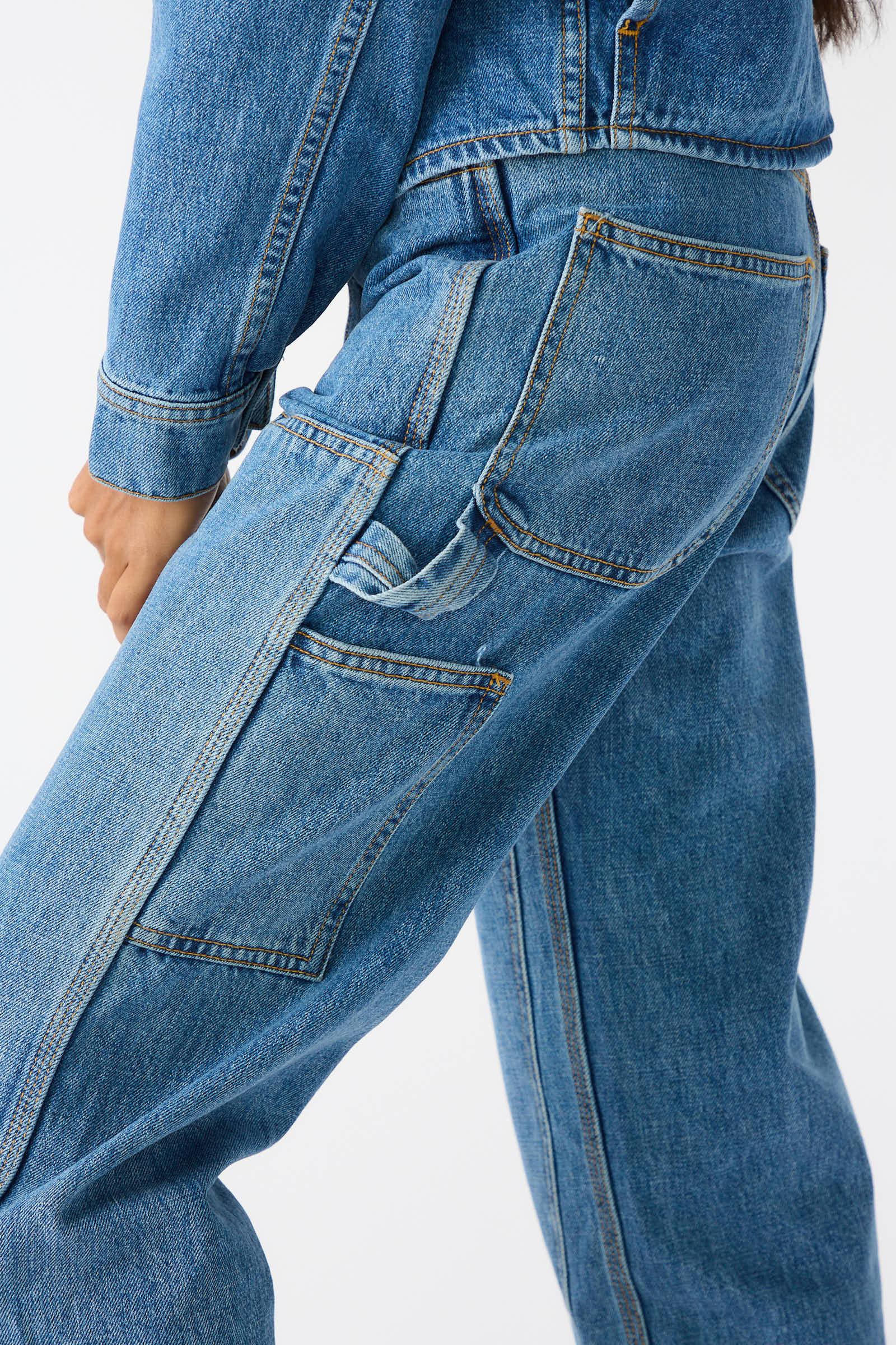 Back view of a person wearing the Japanese Denim Patchfront Handy Pant in Cowboy Blue by Jesse Kamm, featuring large pockets and crafted from high-quality Japanese denim. The relaxed fit pants are paired with a matching blue denim jacket.