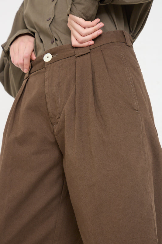 A woman wearing Jesse Kamm's The Trouser in Mushroom and a green shirt.