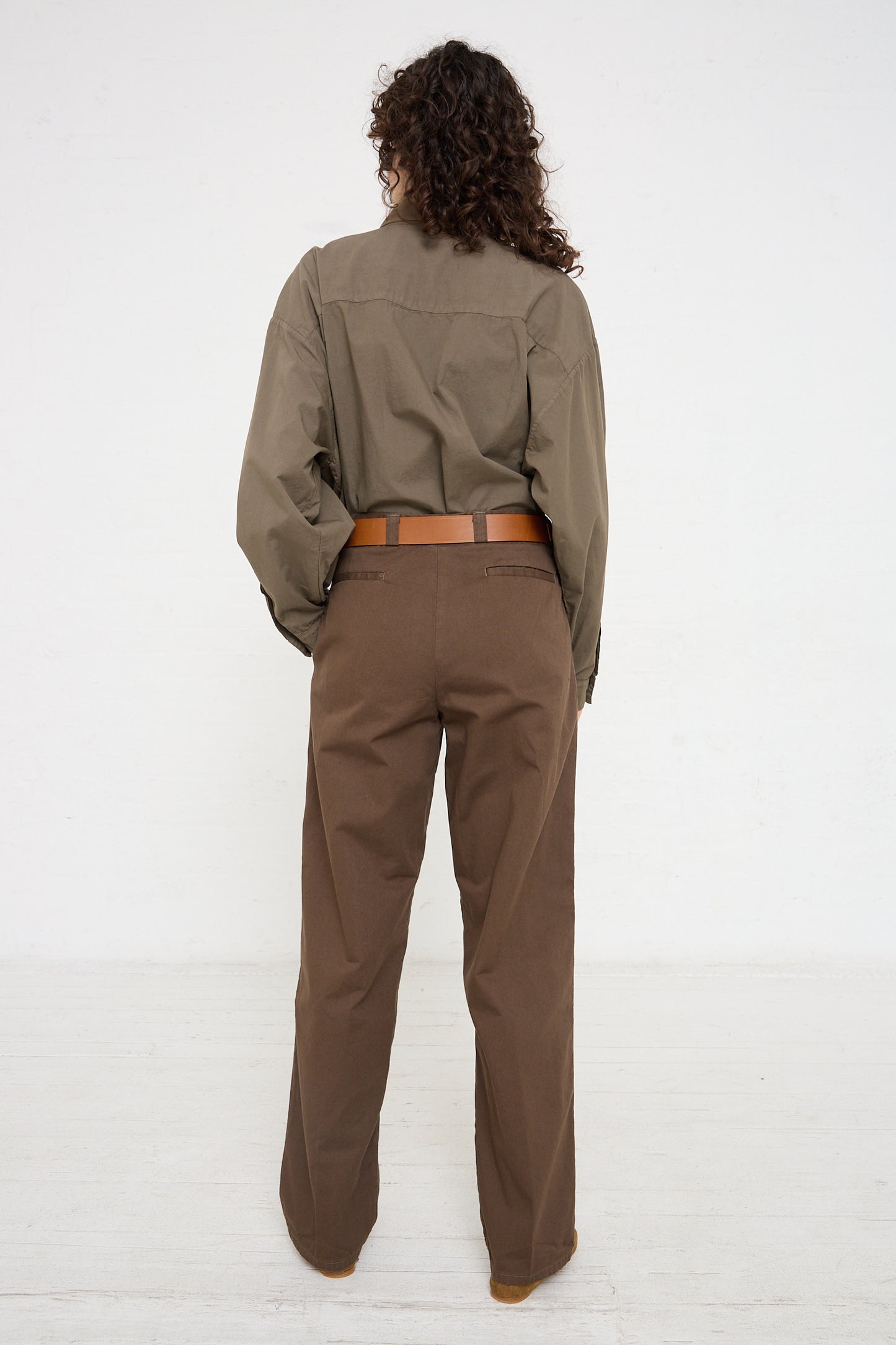 The woman is wearing Jesse Kamm trousers in Mushroom, giving a relaxed and comfortable fit.