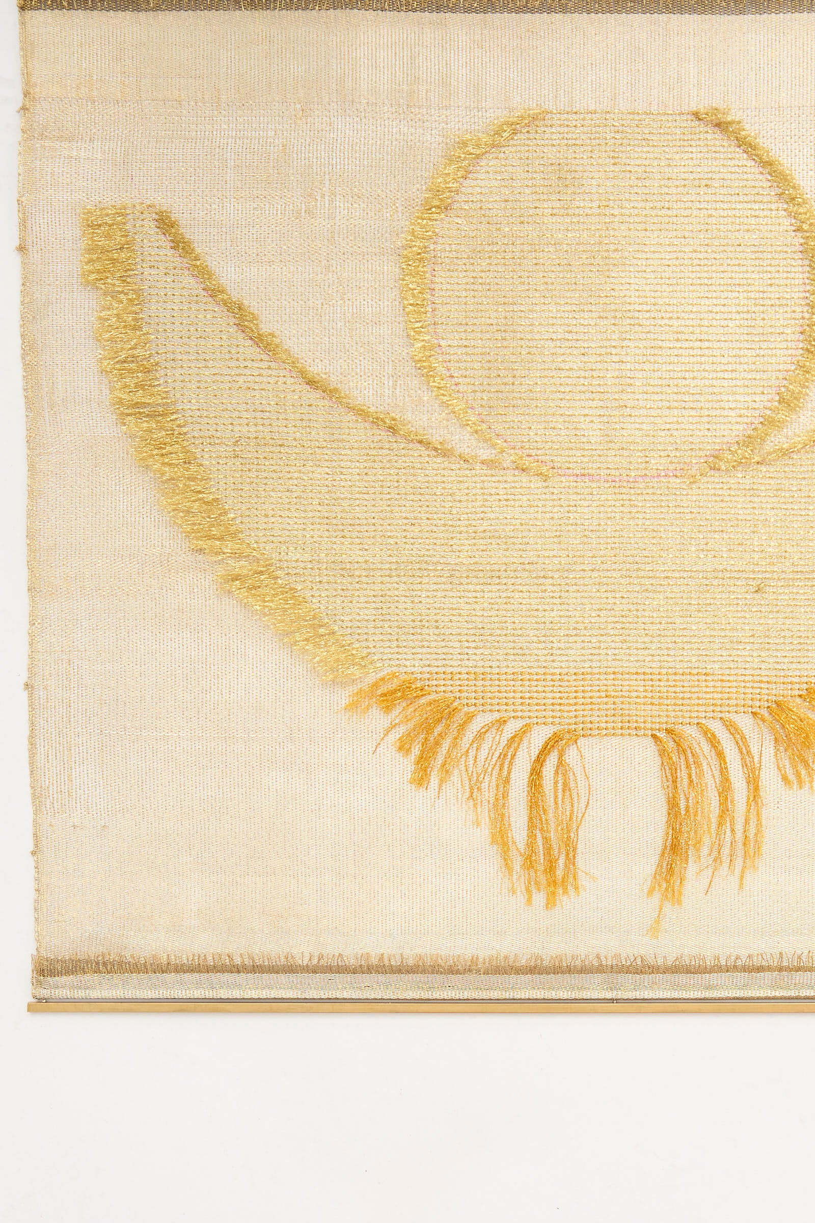 The Hermes Crescent Moon Weaving by Justine Ashbee is a handmade UK wall hanging with a beige background, featuring a gold semicircular moon, gold circle, and gold fringe at the bottom.