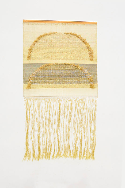 The Two Suns Rising Weaving by Justine Ashbee is a handmade UK textile art piece with two stacked light yellow semicircles and long fringe, creating an elegant rectangular wall hanging for modern interiors.