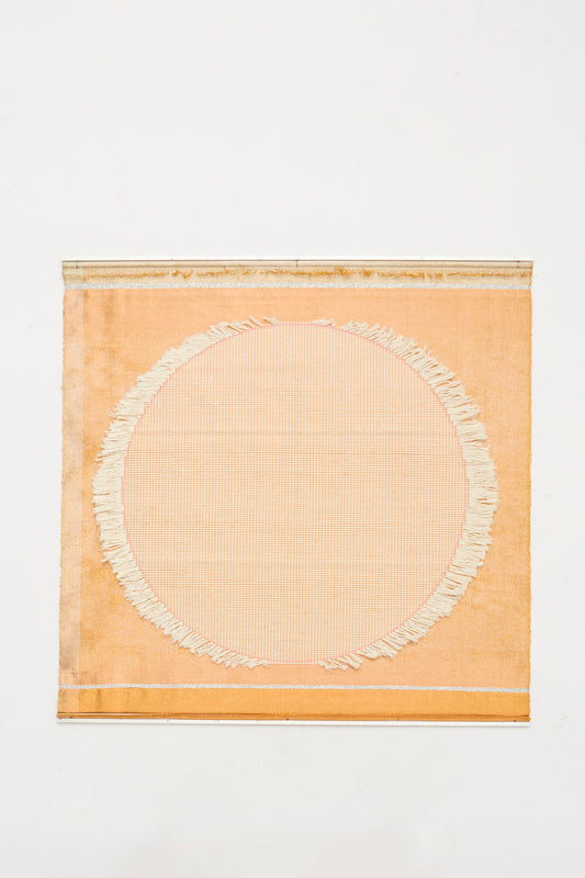 The White Moon Weaving by Justine Ashbee is a handmade square orange textile from the UK, showcasing a large off-white fringed circle in the center, displayed on a plain white background.