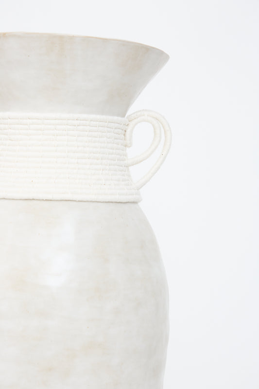 Close-up of a Vase #810 in White stoneware pitcher by Karen Tinney with a textured band and handle.