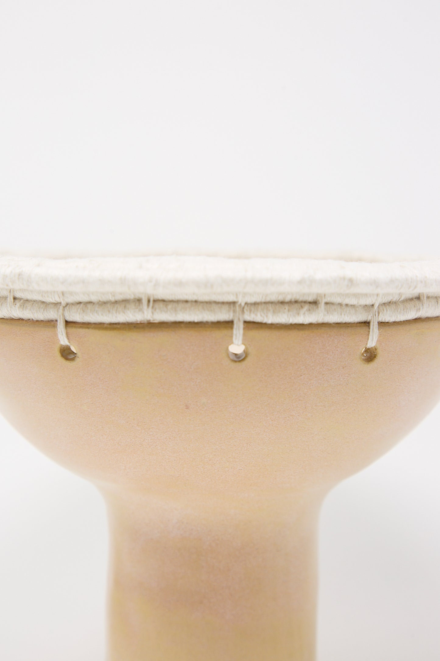 Close-up of a Karen Tinney Decorative Bowl #805 in Tan with tension rods on a white background.