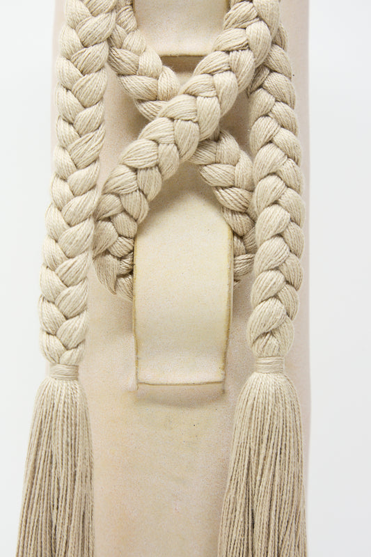 Close-up of a decorative knot and tassel on a Karen Tinney Vase #696 in Tan satin fabric.