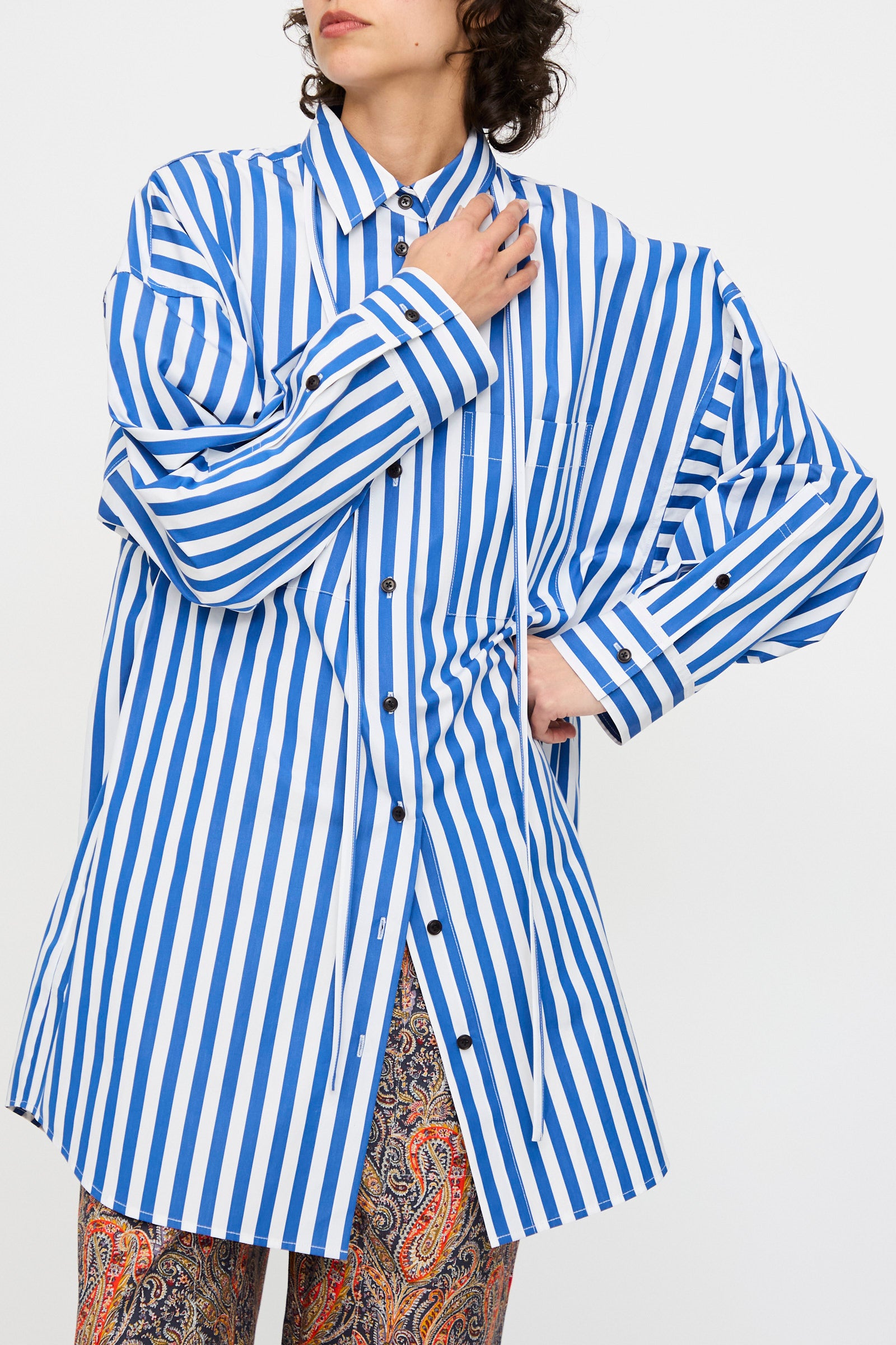A person wearing the KasMaria Cotton Poplin Oversized Dress with Tie in Stripe, standing against a plain background.