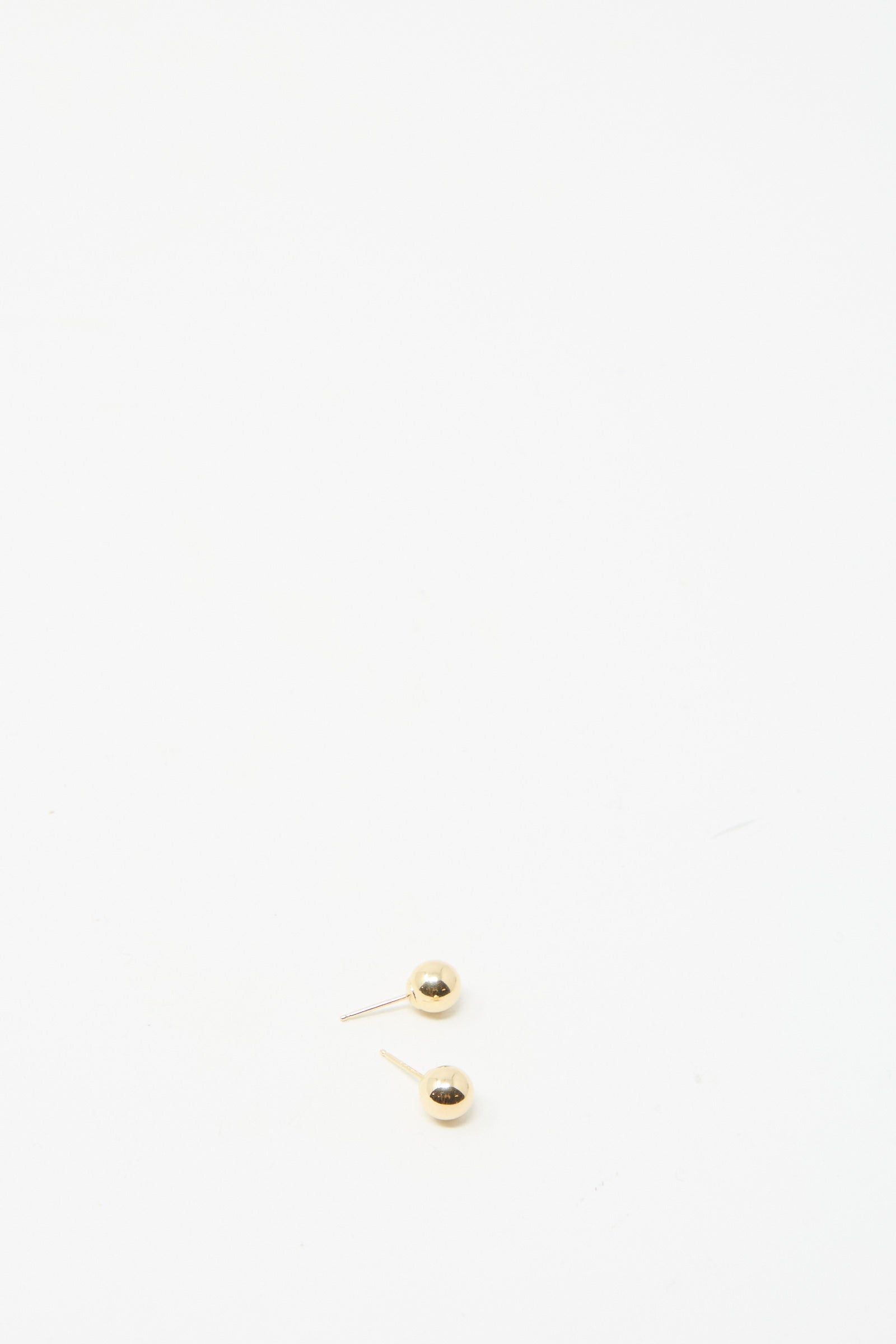 Kathleen Whitaker's 14K Yellow Gold Sphere Stud Small 6mm earrings offer an elegant, precise design featuring two small hollow spheres on a white background.