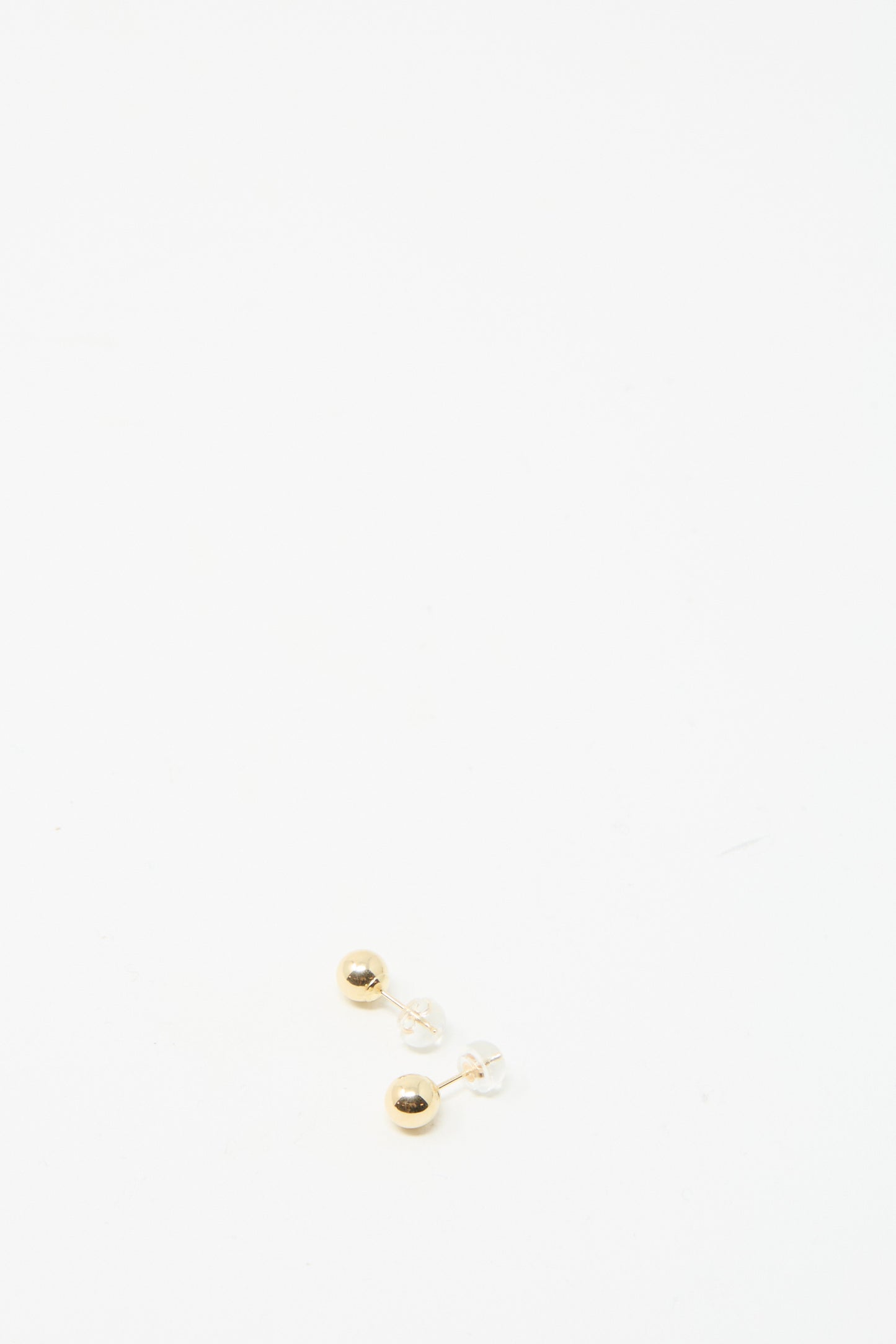 A 14K yellow gold sphere stud, reminiscent of elegant earrings by Kathleen Whitaker, sits on a plain white background showcasing exquisite craftsmanship often associated with Los Angeles jewelry.