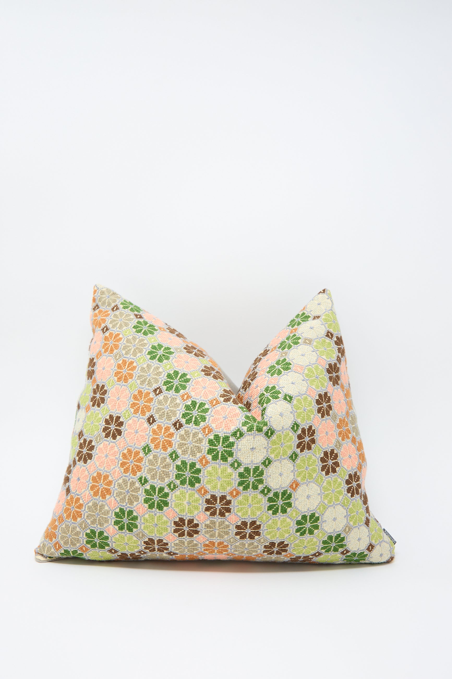 A one-of-a-kind Damask Rose Hand Embroidered Pillow in Coral and Olive featuring a pattern of green, orange, brown, and white flowers on a light background made from luxurious Libeco Belgian linen by Kissweh.