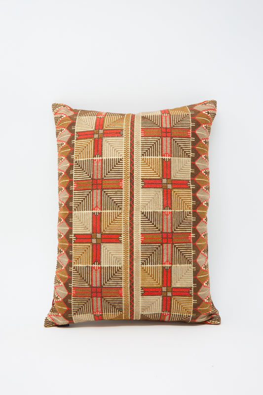 A Kissweh Ensaf Hand Embroidered Pillow in Chocolate with a geometric, multicolored pattern in shades of brown, red, green, and beige set against a plain white Belgian linen background.