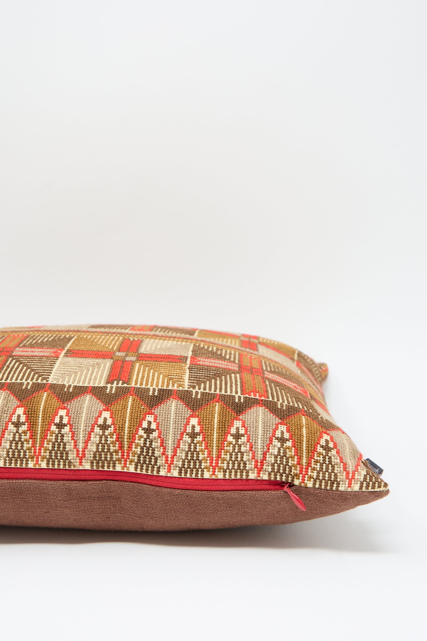 A Kissweh Ensaf Hand Embroidered Pillow in Chocolate, featuring an intricate pattern in shades of red, beige, and brown with exquisite hand embroidery, placed against a plain white background.