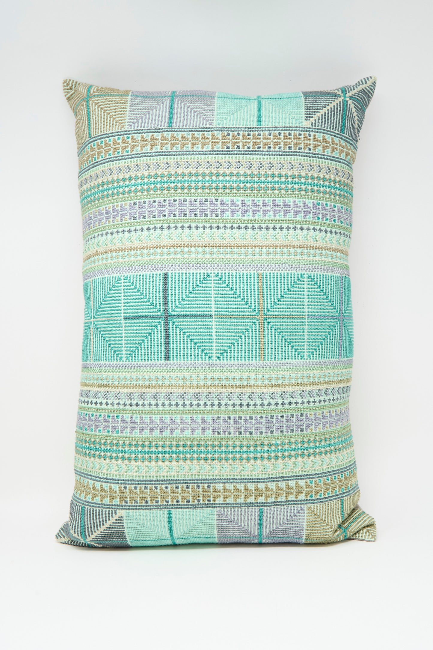 The Hanan Hand Embroidered Pillow in Acqua I by Kissweh features a geometric design in green, blue, and beige on white Belgian linen, and includes a plush down feather insert for extra comfort.