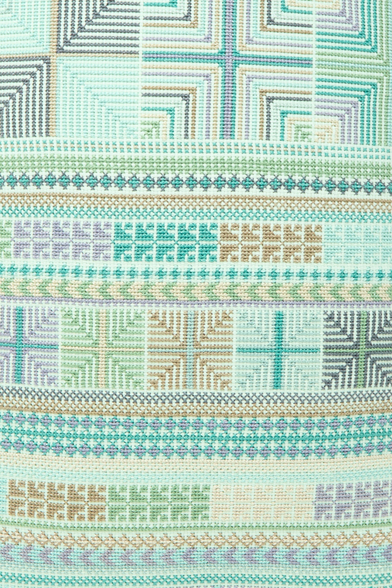 The Hanan Hand Embroidered Pillow in Acqua II by Kissweh features a geometric cross-stitch design in pastel green, blue, purple, and beige on a plush down feather insert.