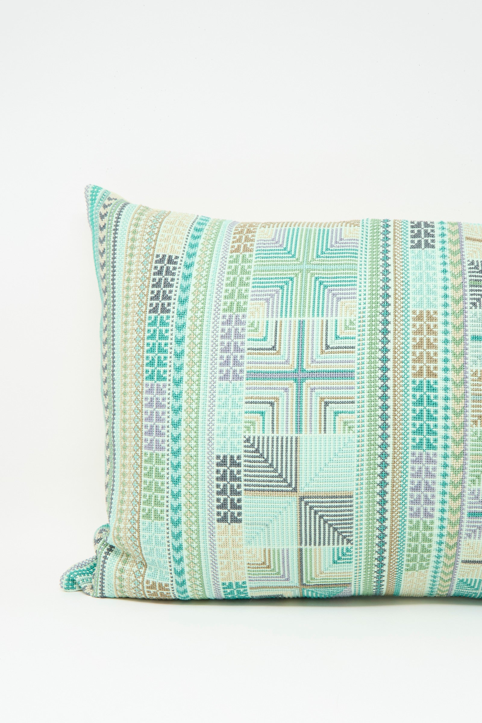 The Hanan Hand Embroidered Pillow in Acqua II by Kissweh features a geometric multicolored pattern in mint green, beige, grey, and white on Belgian linen. Includes a plush down feather insert for extra comfort.