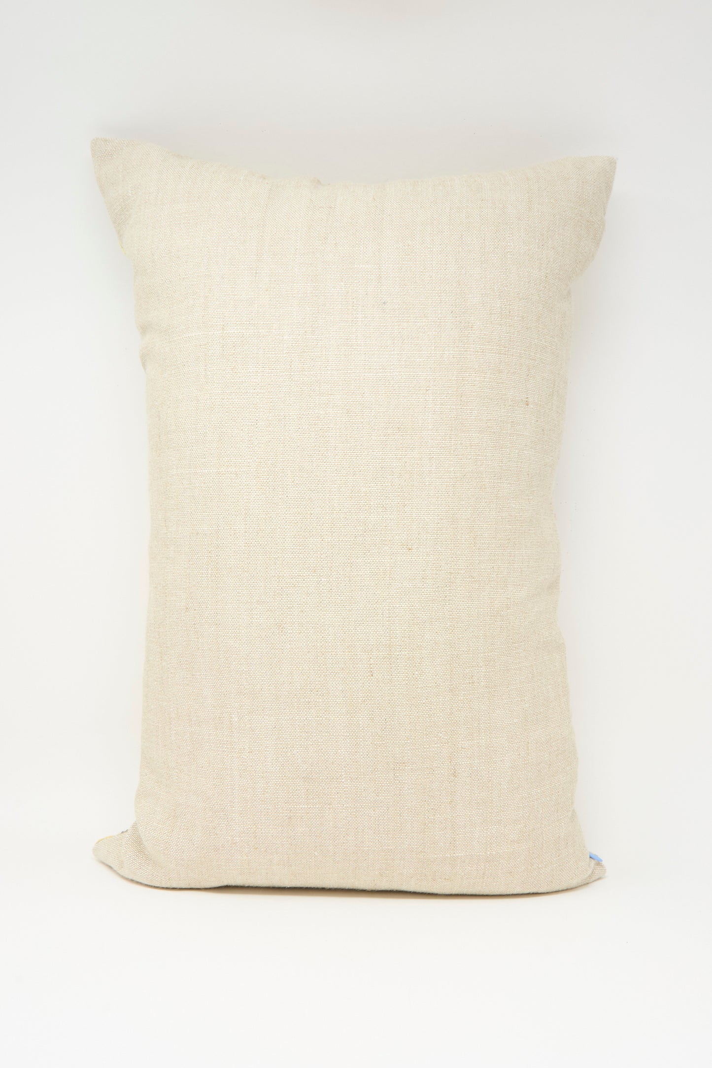 The Hanan Hand Embroidered Pillow in Mustard by Kissweh, with its rectangular shape, stands upright against a white background.