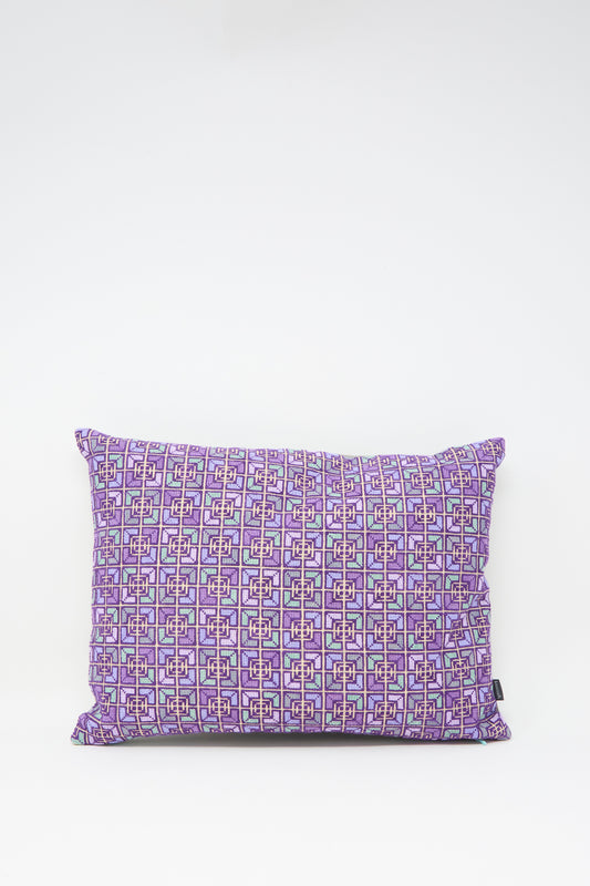 The Kissweh Rana Hand Embroidered Pillow in Lilac and Purple I features a rectangular design with a purple geometric pattern on white Belgian linen.