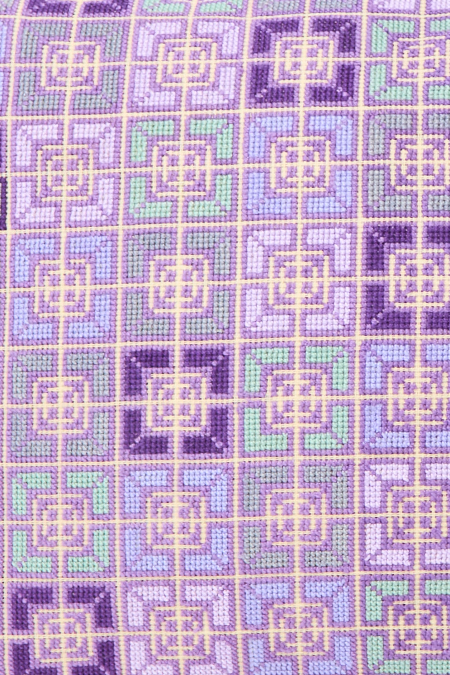 The Rana Hand Embroidered Pillow in Lilac and Purple II by Kissweh features a geometric pattern in purple, lavender, green, and yellow on Belgian linen with a plush down feather insert.