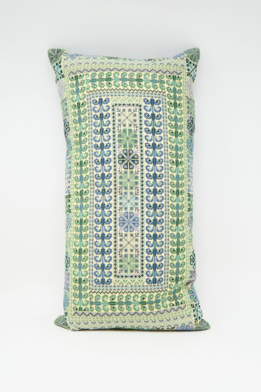 The Yasmin Hand Embroidered Pillow in Olive by Kissweh features intricate blue and green geometric embroidery on premium Belgian linen, beautifully displayed against a plain white surface.